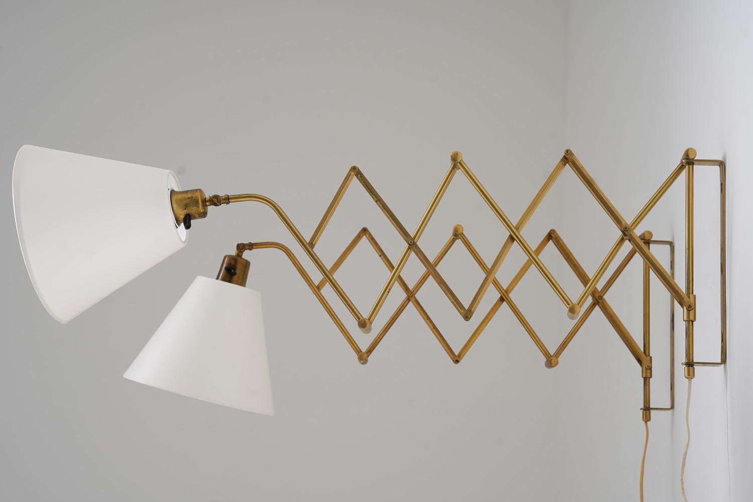 Exquisite scissor lamps in brass by ASTRA, Norway, crafted in the 1960s. These extendable lamps feature a sleek, timeless design and can be adjusted to a maximum length of 100 cm (39