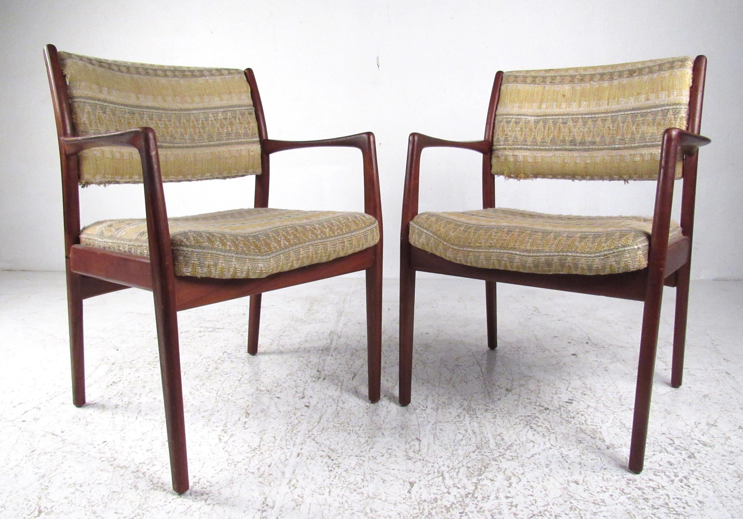 Classic pair of Danish style midcentury teak armchairs ideal for any home or office environment. Featuring sculpted arms with a thick upholstered seat and back, these chairs are both comfortable and stylish and will compliment any seating