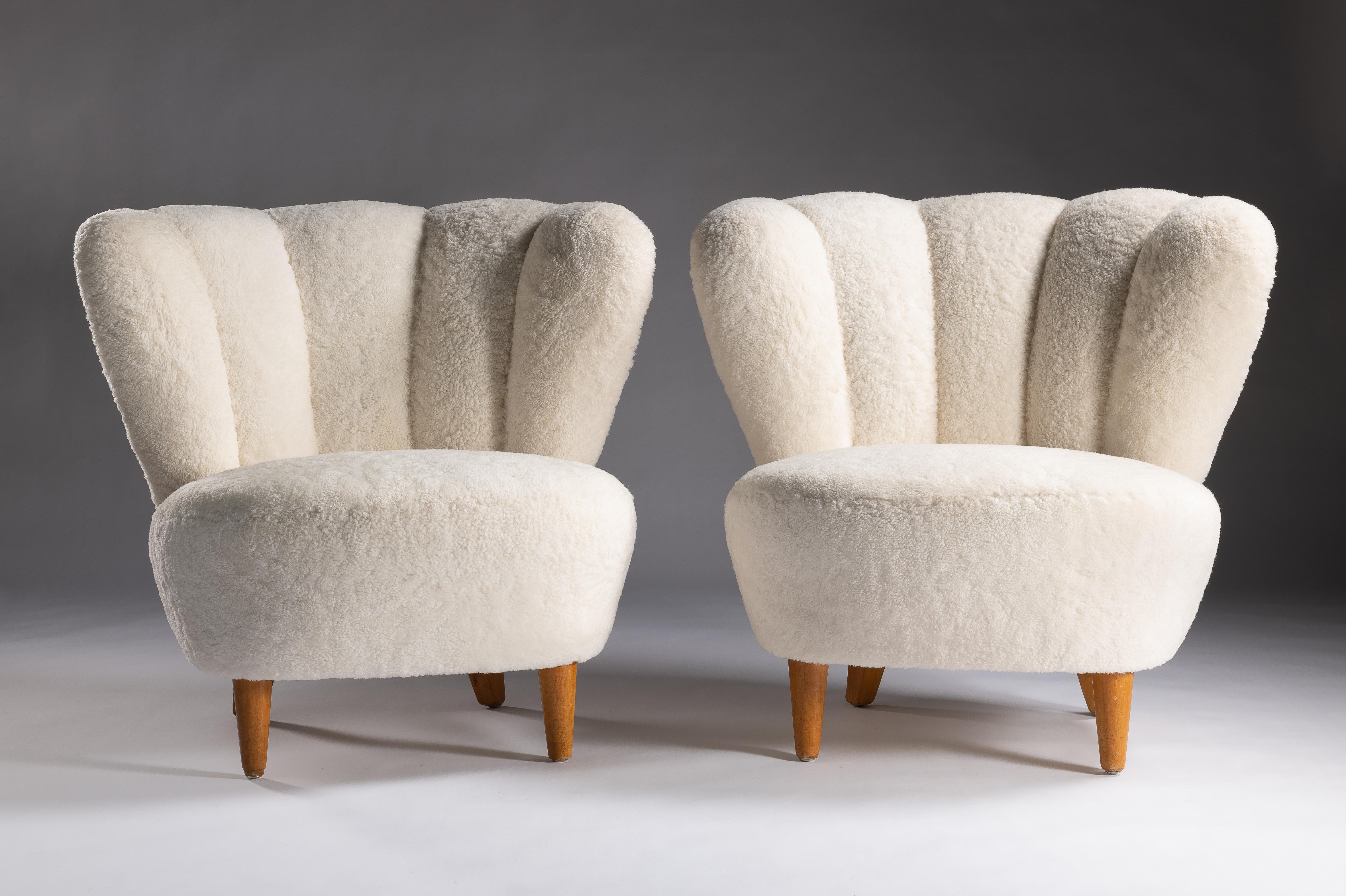 A pair of Scandinavian Vintage armchairs.
Made in the 1950s, the design was produced in Central European furniture factories throughout the mid-20th Century. 
The eye-catching silhouette and comfortable shape has had an enduring appeal. Influenced