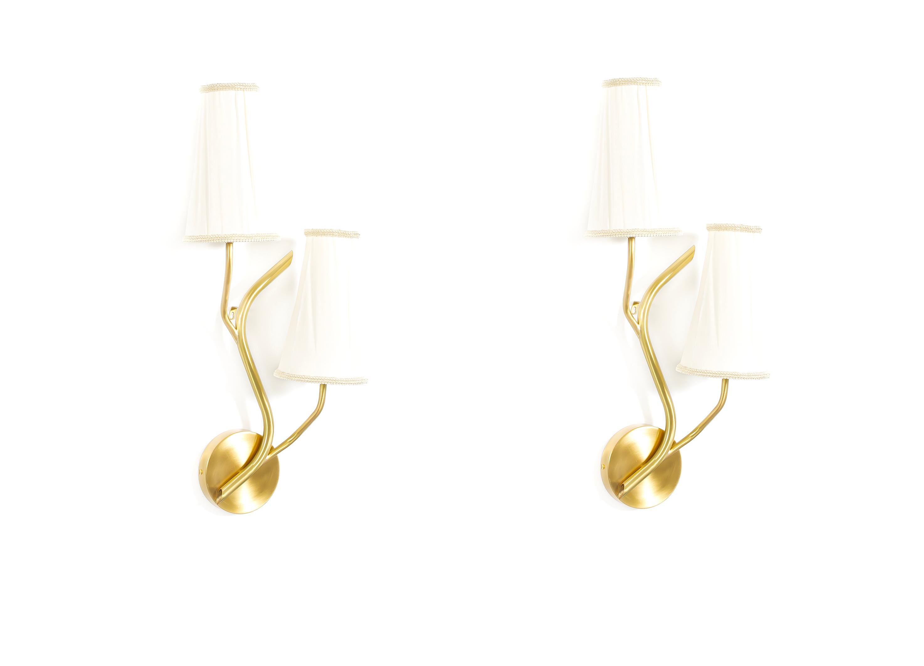 Wonderful pair of sculptural, organic, and decorative wall lights in brass with two arms and soft nylon shades. Designed in Norway by Astra and crafted by skilled artisans, these refined fixtures take inspiration from the rich legacy of Norwegian