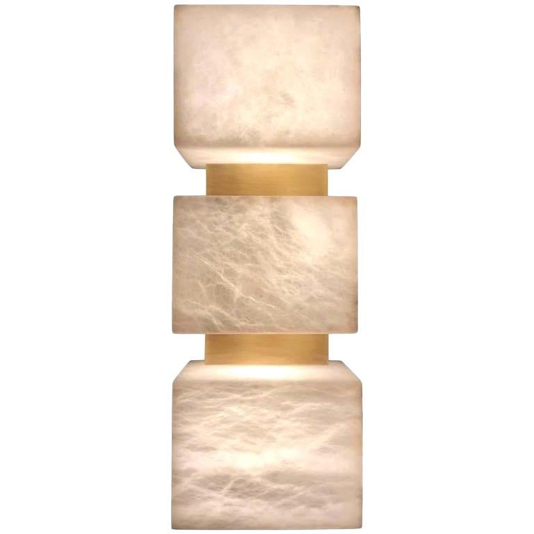 Designed by Simon Stewart for Charles Burnand the Scatola wall sconce is made from alabaster with brushed patinated brass. Alabaster has a unique fluidity to its appearance when back lit. Being a natural material, each piece is unique. The degree of