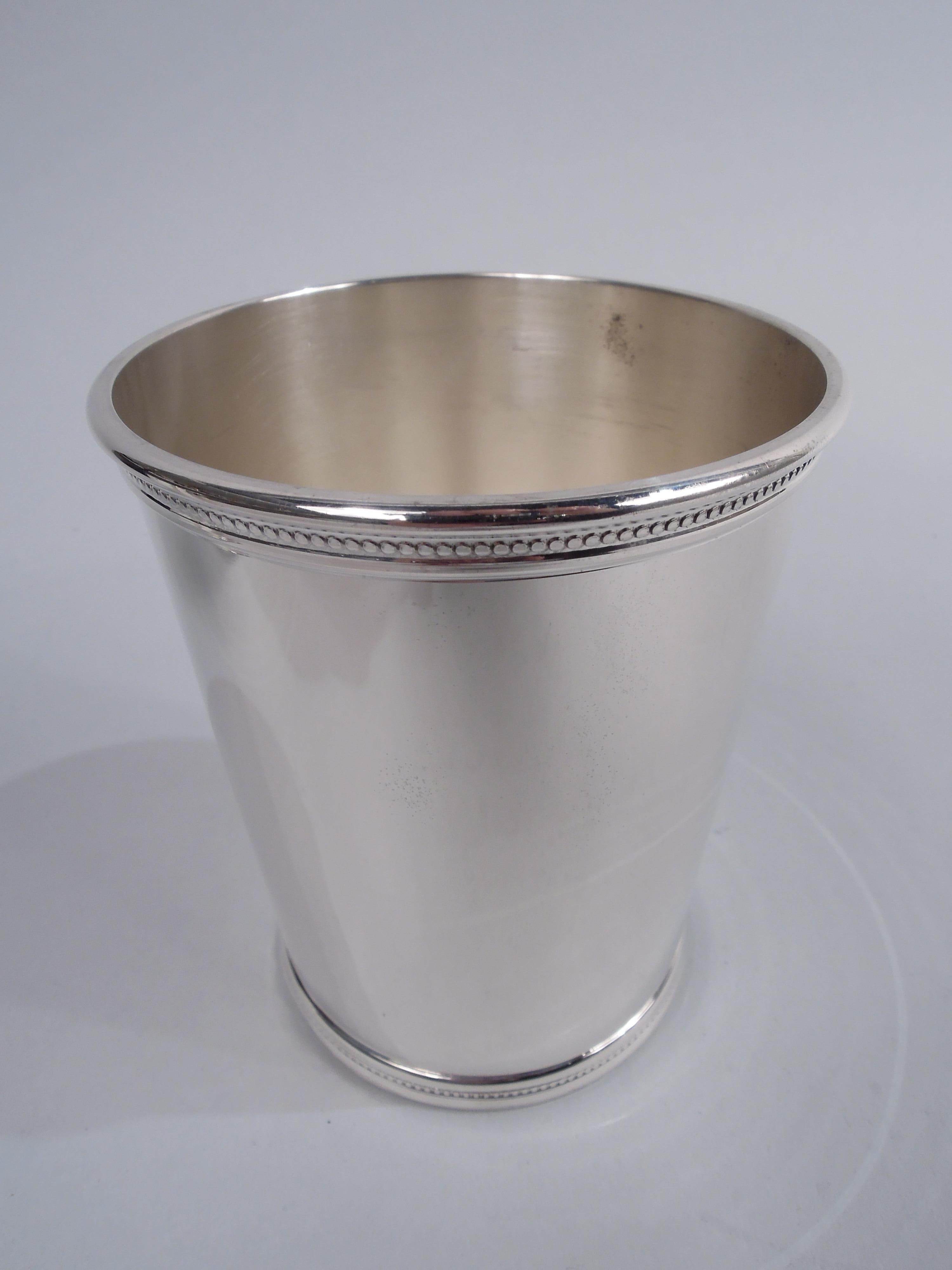 Pair of Eisenhower-era sterling silver mint juleps. Made by Scearce in Shelbyville, Kentucky. Straight and tapering sides, and beaded and molded rim and foot. A great way in these tumultuous times to get back in touch with your inner country club