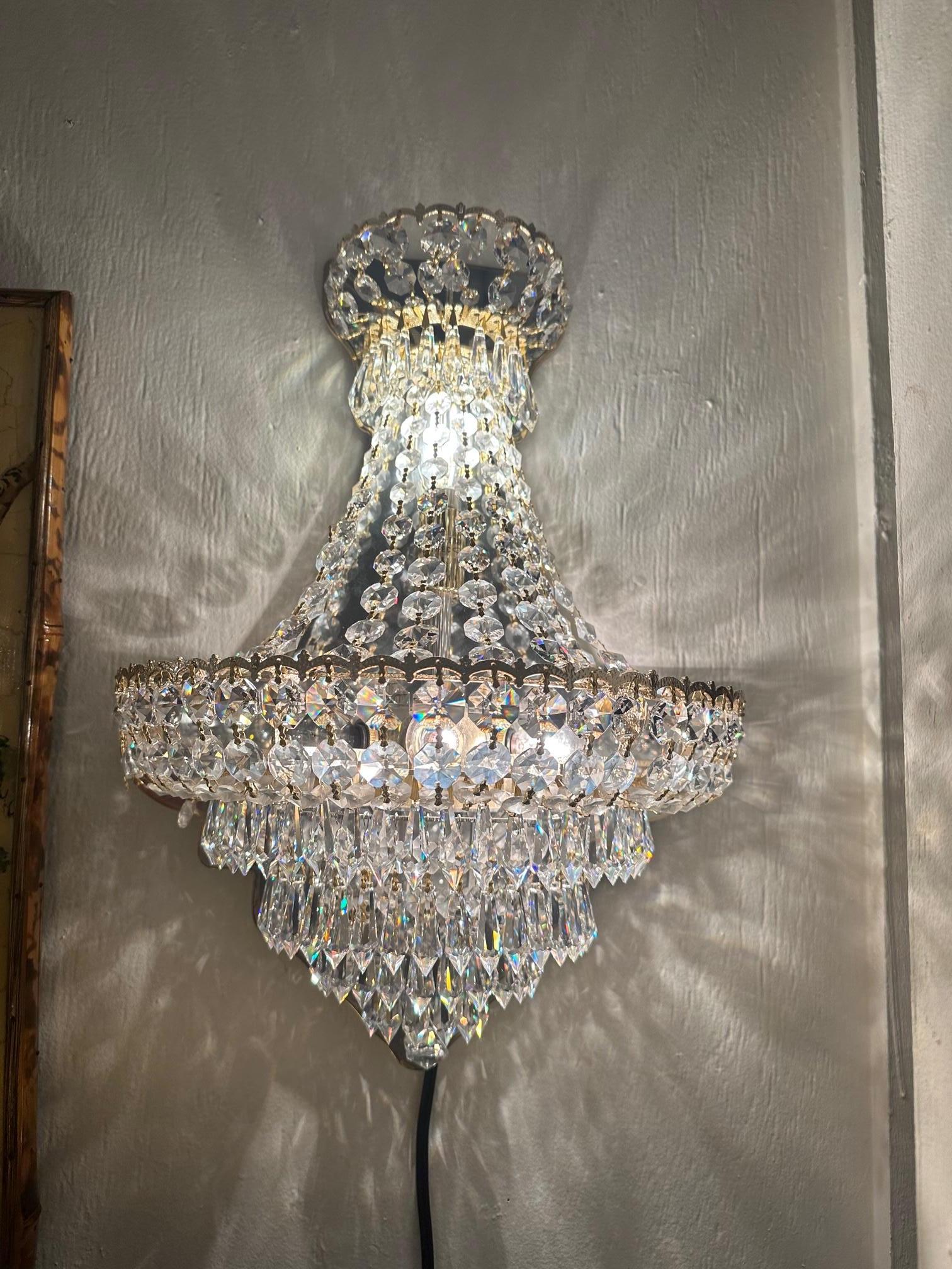 Moviestar glamorous pair of glistening ornate Schonbek sconces having necklaces of dripping crystals and gold plated armature with 4 interior lights. Discontinued in 2013 because of unavailablity of the crytals. These were never used, and originally