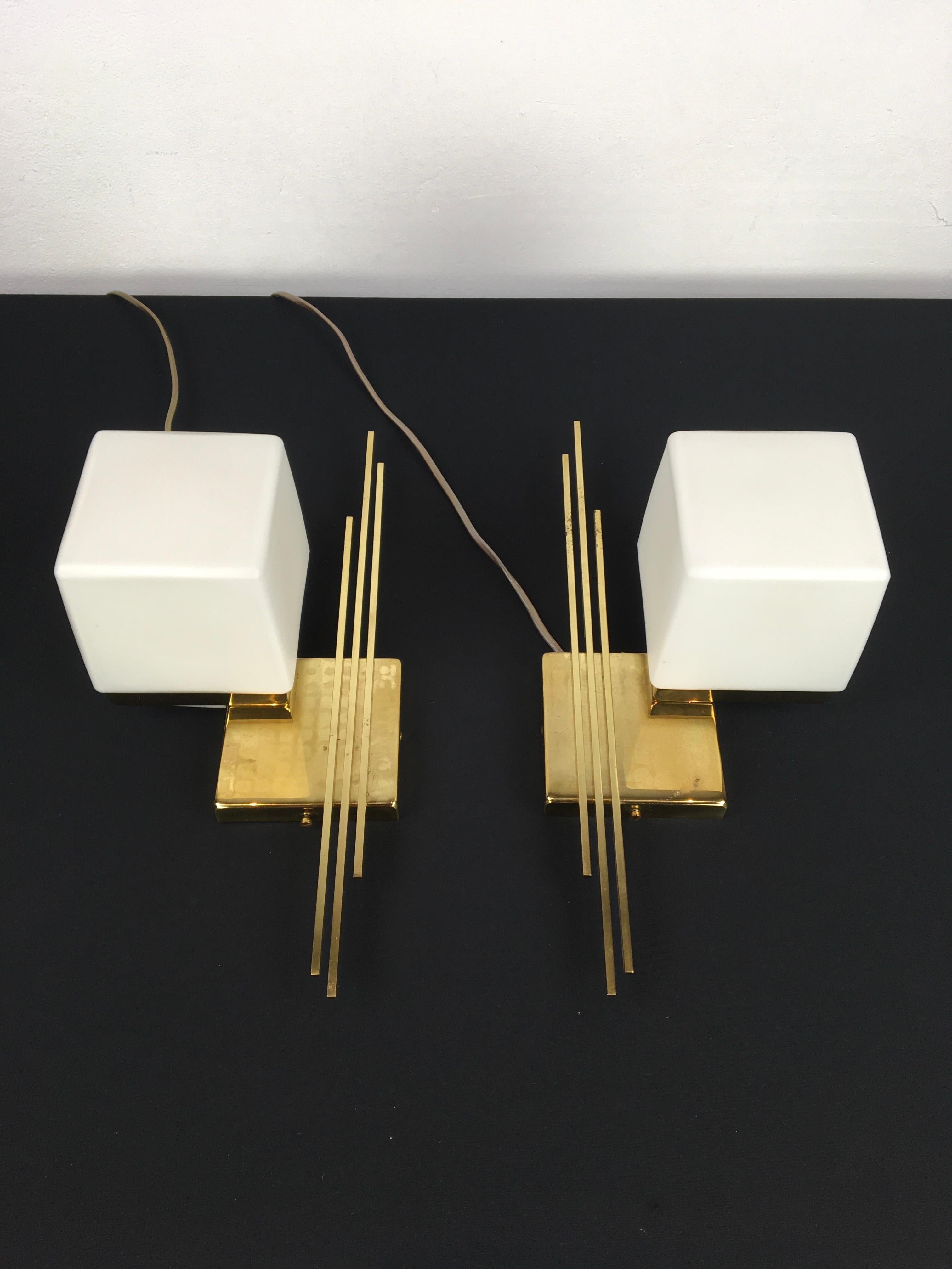 Pair of Sciolari wall lights.
These Sciolari wall scones have a cube shaped base with each 3 lines or stripes
and cube or square milk glass shades. Inside there are white porcelain fittings for E14 fitting.

These lights can be hang in the position