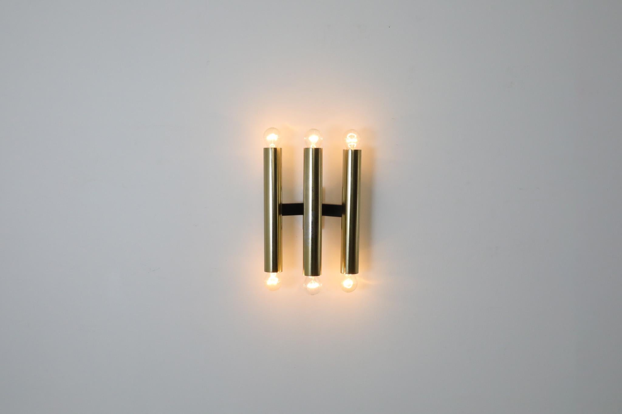 Paire d'appliques murales à bras multiples de style Gaetano Sciolari, en laiton, avec montures noires. Elles sont équipées d'ampoules standard à culot moyen, 3 sur le dessus et 3 sur le dessous. L'une est représentée avec des ampoules à pointe
