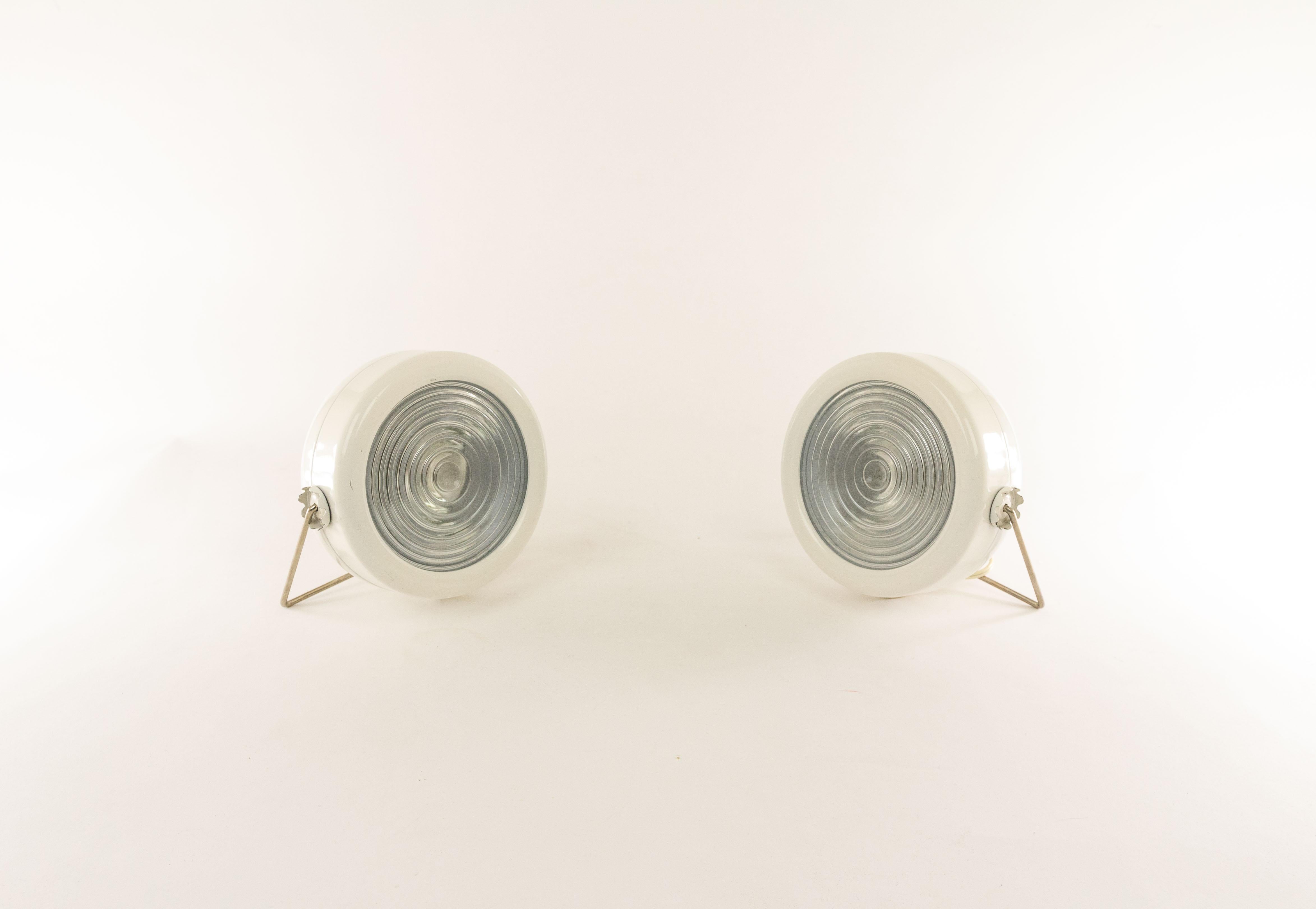A pair of Sciuko lamps designed in 1966 by Achille & Pier Giacomo Castiglioni and produced by the Italian lighting manufacturer Flos.

The lamp consists of a enameled metal body with two gears which allow the bracket to lock into different
