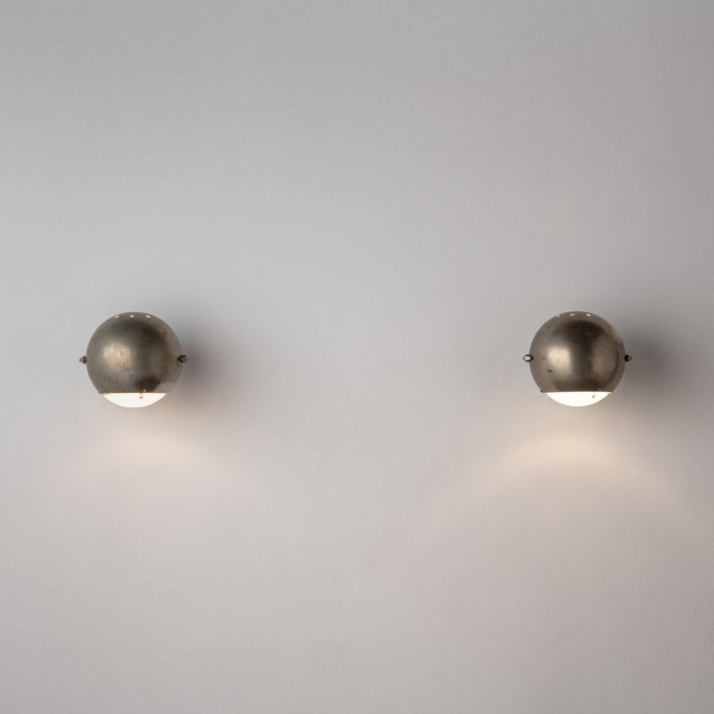 Pair of Sconces by Angelo Lelli. Designed and manufactured in Italy, circa 1950's. Nickel, glass. Rewired for U.S standards. Adjust left/right. Custom nickel backplate. We recommend one E14 60w maximum bulb per fixture. Bulbs not included.