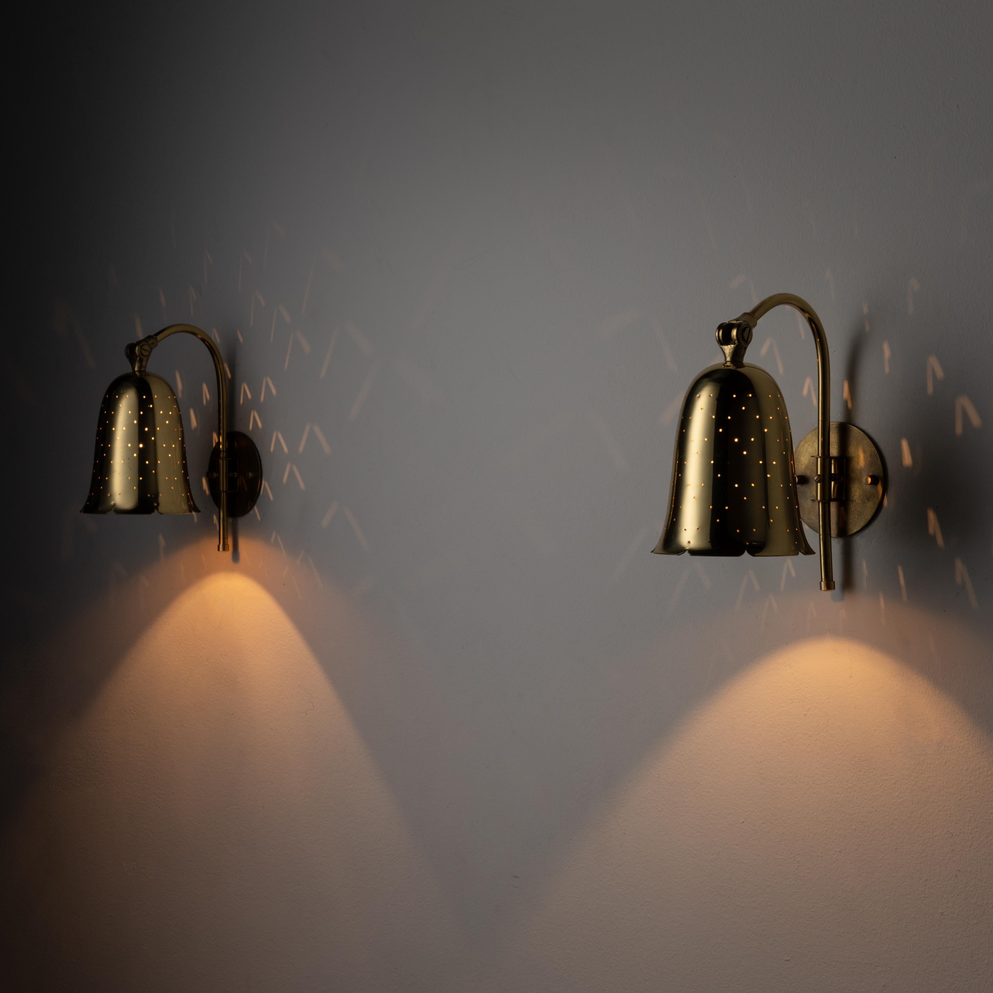 Pair of bell sconces by Boréns Borås. Designed and manufactured in Sweden, circa 1950. Polished brass bell sconces with delicate perforations throughout, giving off a starry light diffusion when lit. We recommend using a 40w maximum E27 bulb.