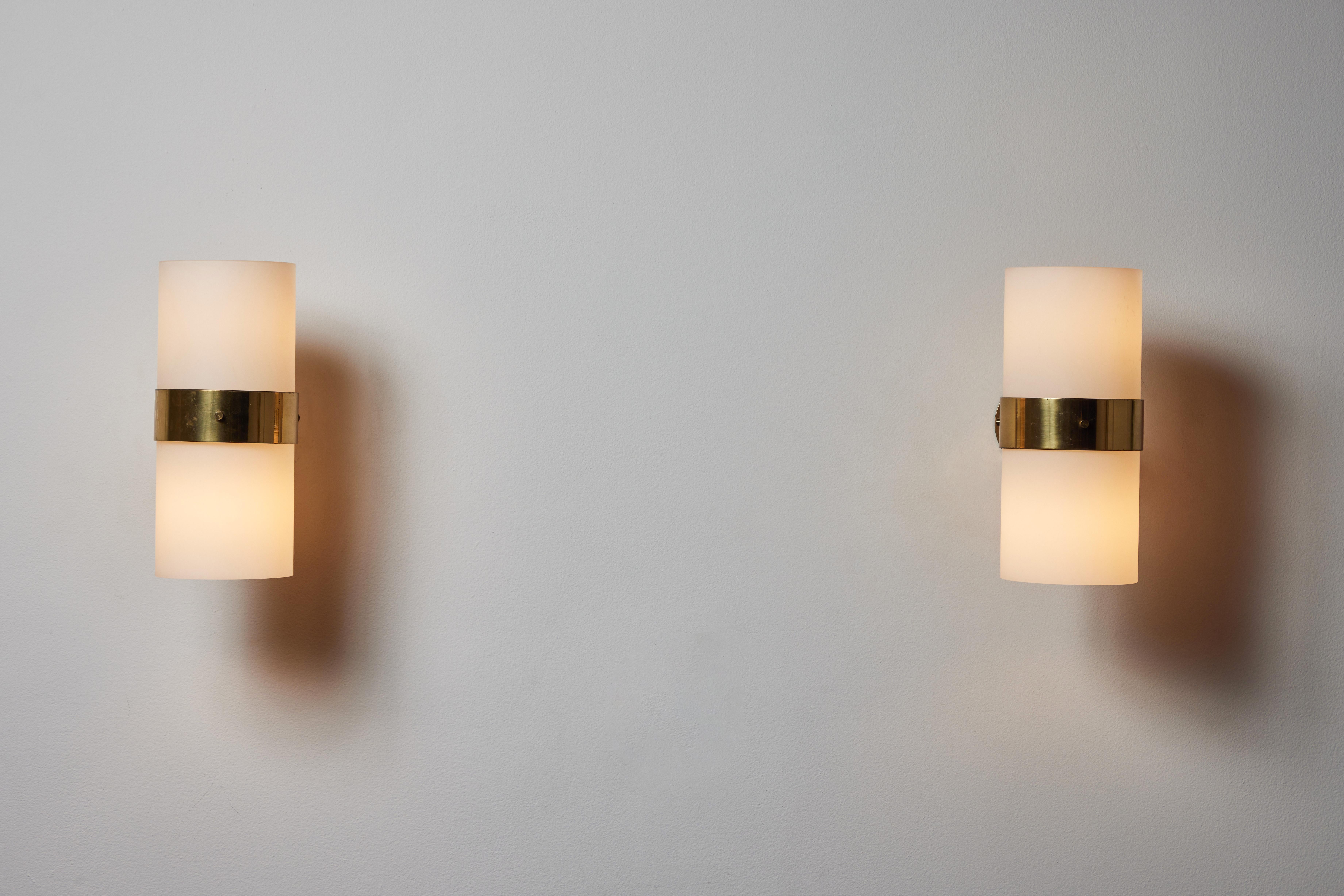 Pair of sconces by Candle. Manufactured in Italy, circa 1960s. Opaline glass diffuser, brass hardware. Custom brass backplates. Rewired for U.S. standards. We recommend two E26 bulbs per sconce Bulbs provided as a one time courtesy.