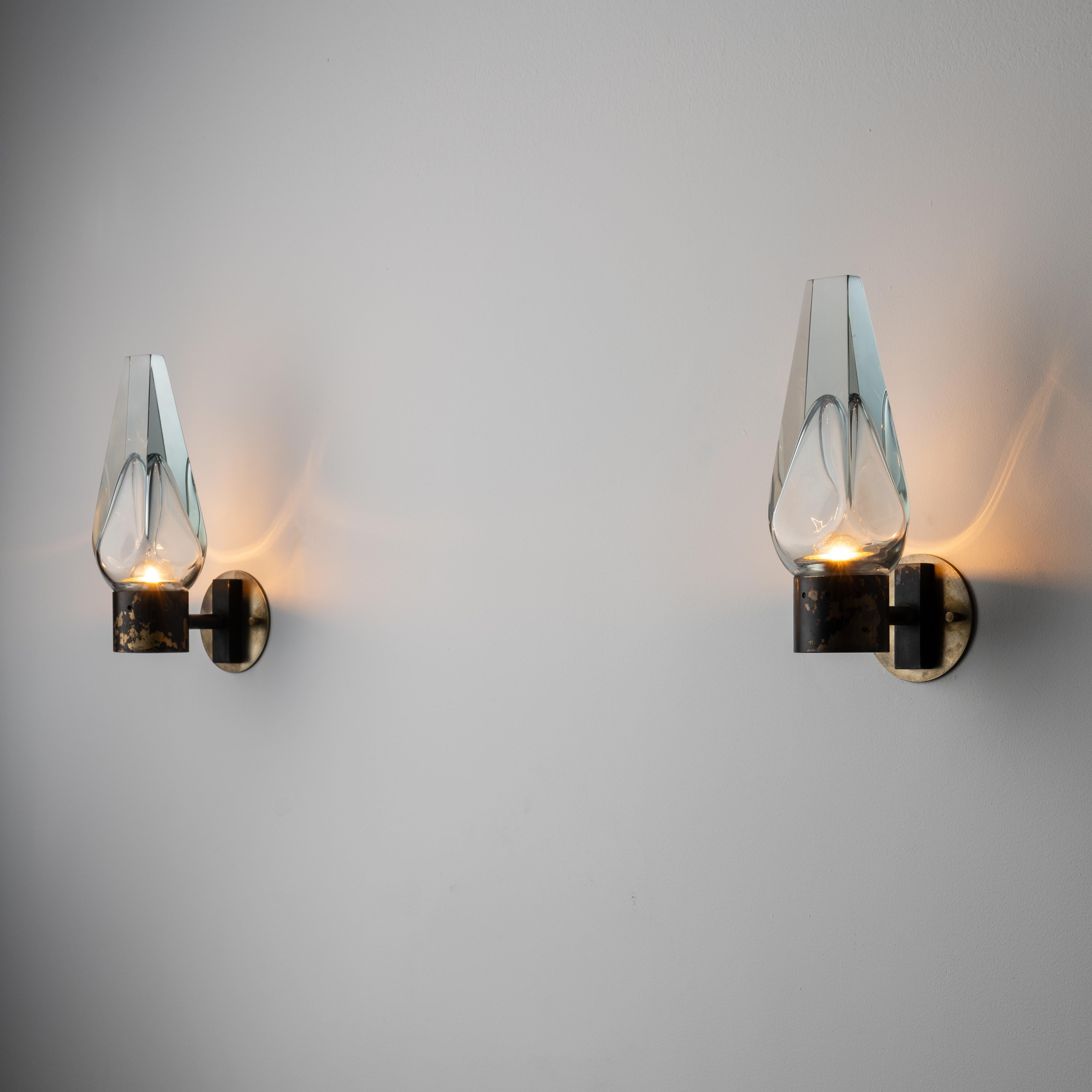 Sconces by Flavio Poli for Seguso. Designed and manufactured in Italy, circa the 1960s. Beautiful thick tapered glass are the main focus of these sconces. The glass has a blue hue and a center relief at the bottom for the bulb to shine through. The