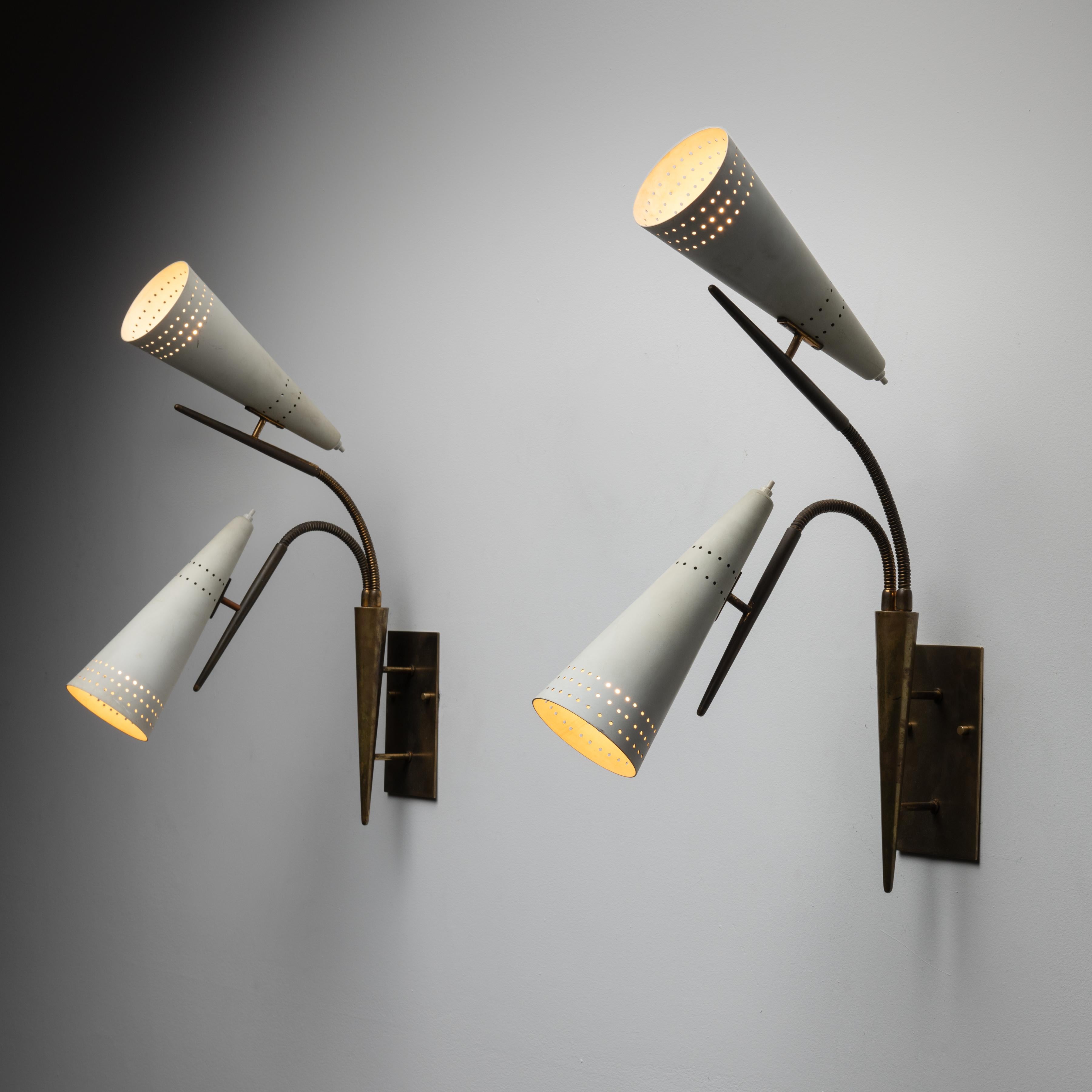 Pair of Sconces by Gilardi and Barzaghi. Designed and manufactured in Italy, circa the 1950s. Two off-white enameled perforated shades are paired onto flex brass arms, allowing the user to chose different positions. Each shade has individually push