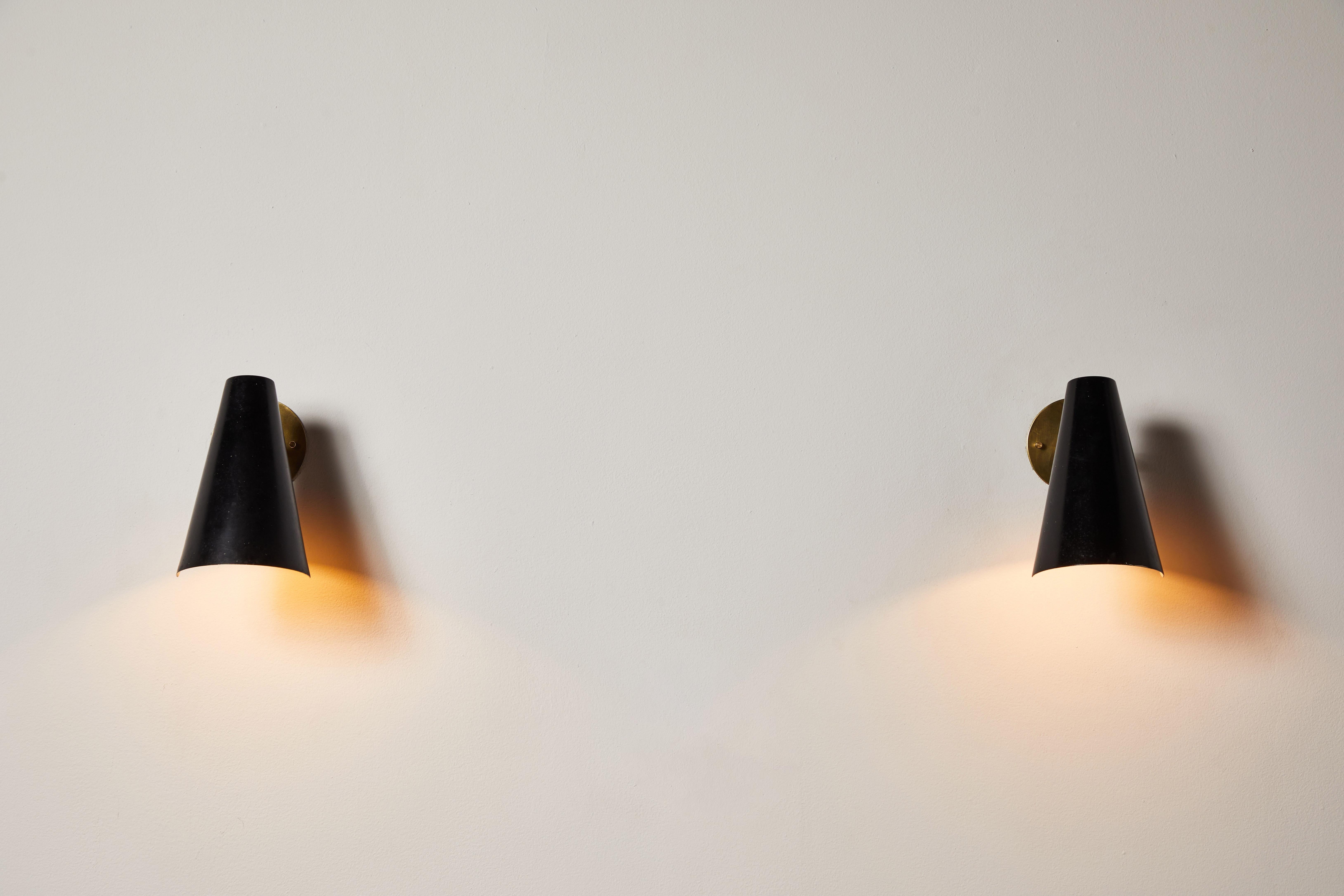 Pair of sconces by Gino Sarfatti for Arteluce. Designed and manufactured in Italy, circa 1950s. Lacquered metal, brass. Rewired for U.S. standards. Shades articulate to various positions. We recommend one E27 100w maximum bulbs per light. Bulbs