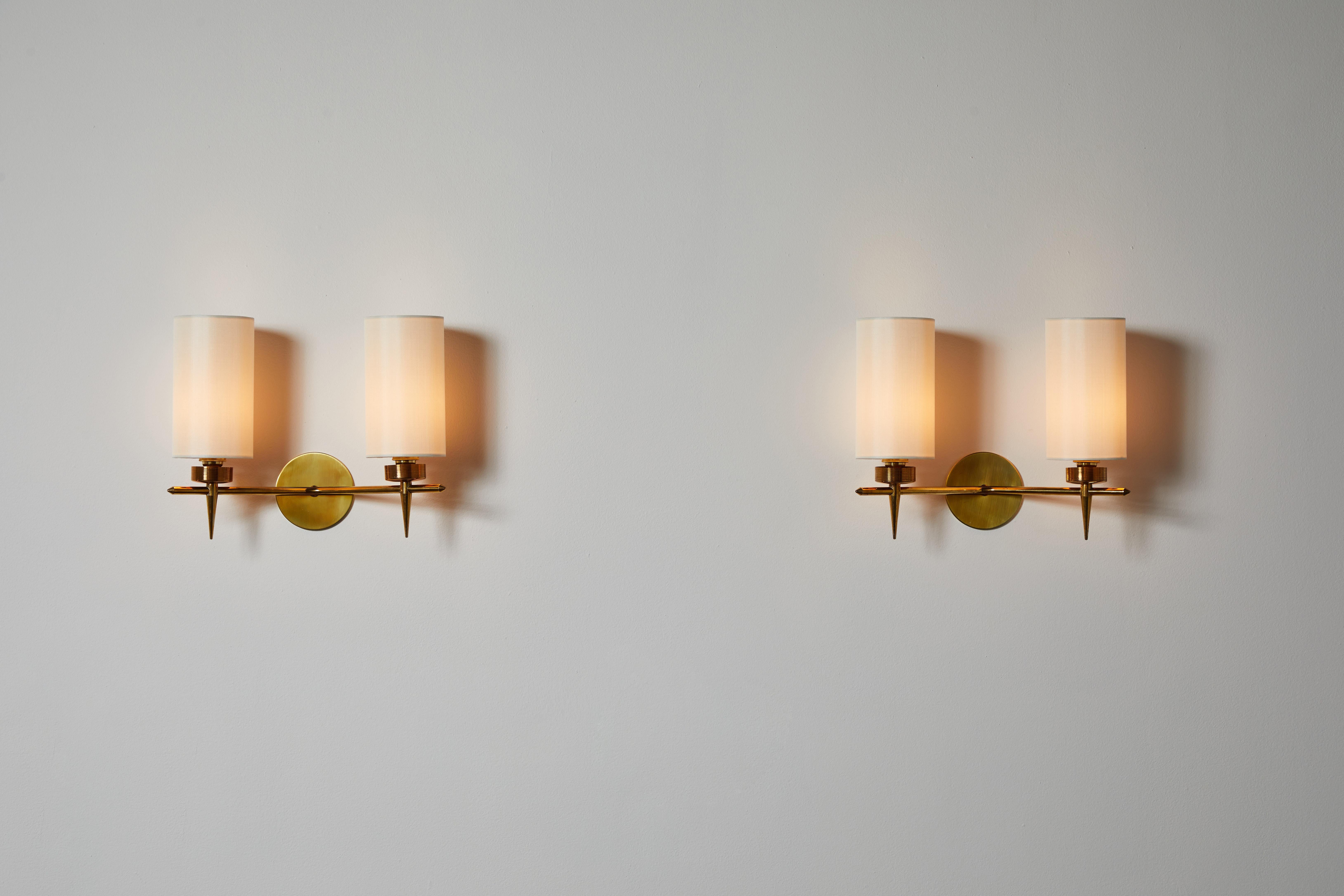 Pair of sconces by Lunel. Designed and manufactured in France, circa 1950s. Brass with custom silk shades. Rewired for U.S. standards. custom brass backplates. These fixtures have one socket each. We recommend one E27 25-40 w maximum bulb. Bulbs