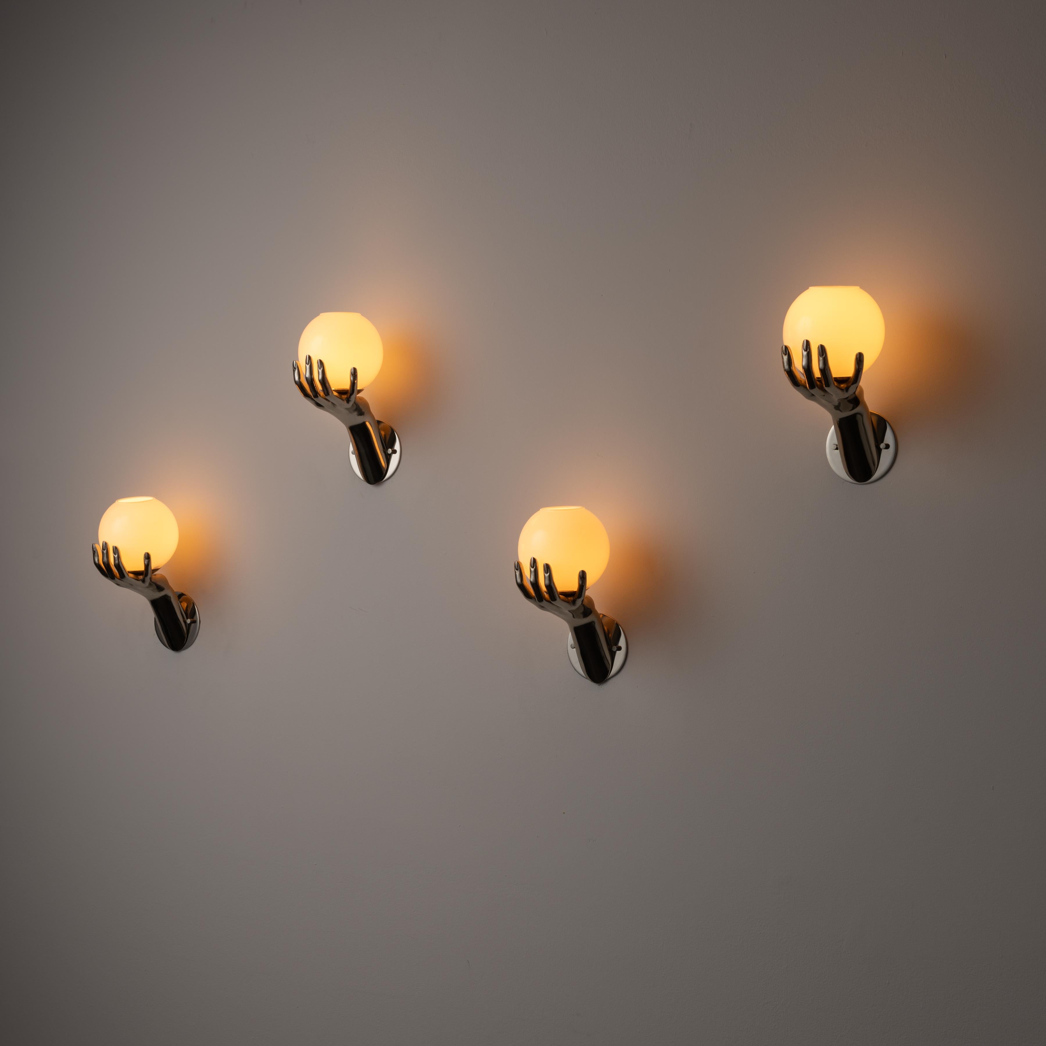 Sconces by Maison Arlus. Designed and manufactured in France, circa the 1970s. Chrome hands with opal glass diffusers. Each glass diffuser has an opened top, allowing for an uplight effect of illumination. Each sconce holds a single E14 socket type,