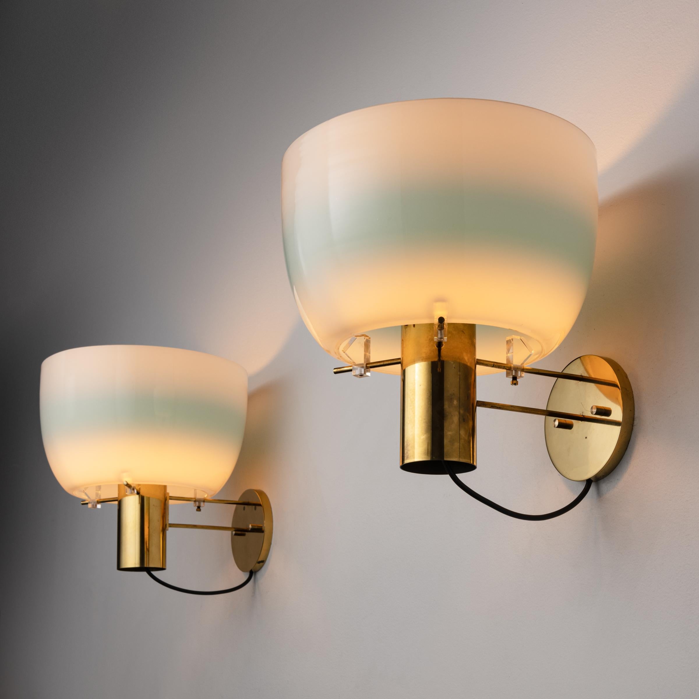 Pair of Model 1121 Sconces by Ostuni & Forti for Oluce. Designed and manufactured in Italy, circa 1950's. Opaline glass, brass, custom brass packplates. Wired for U.S. standards. We recommend : One 75w maximum E27 bulb per fixture. Bulbs not