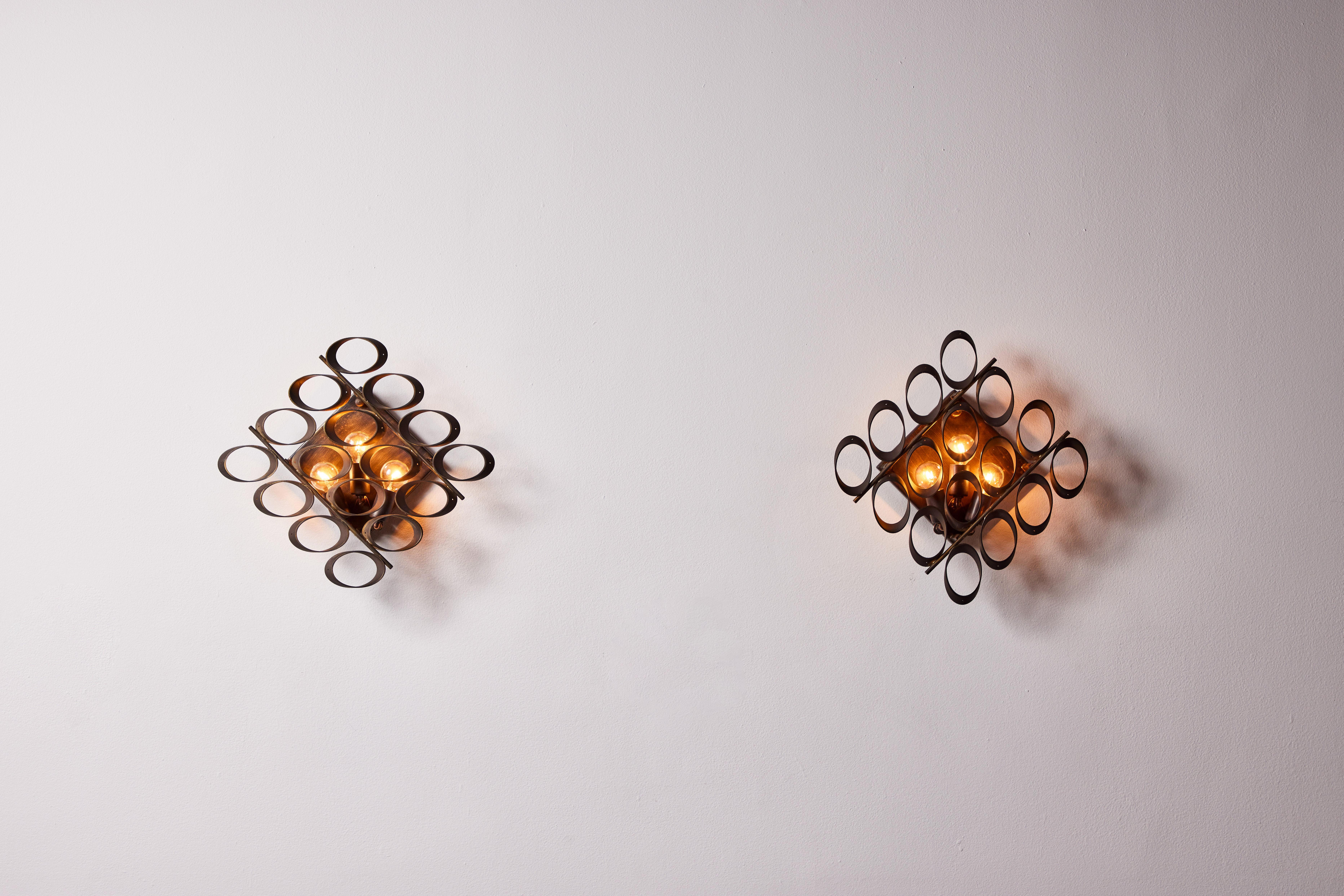 Pair of sconces by Sciolari. Designed and manufactured in Italy, circa 1950s. Brass, custom brass backplates. Rewired for U.S. standards. We recommend 3 E12 20w candelabra per sconce. Bulbs provided as a one time courtesy.