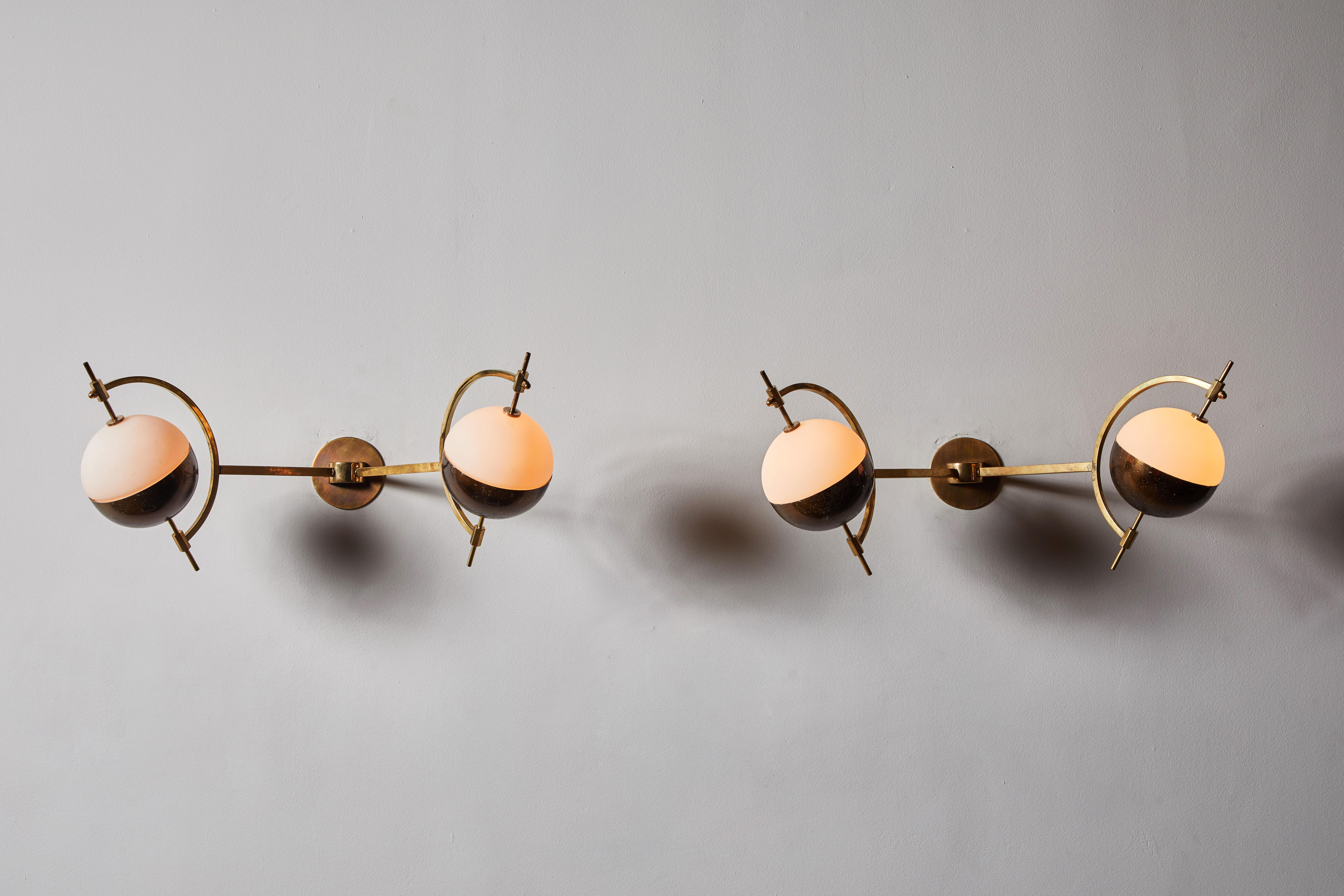 Pair of Sconces by Stilnovo. Manufactured in Italy, circa 1950s. Brass with brushed satin glass diffusers. Custom brass backplate. Each light takes one E27 candelabra bulbs, 40 watts/maximum. Bulbs provided as a one time courtesy.