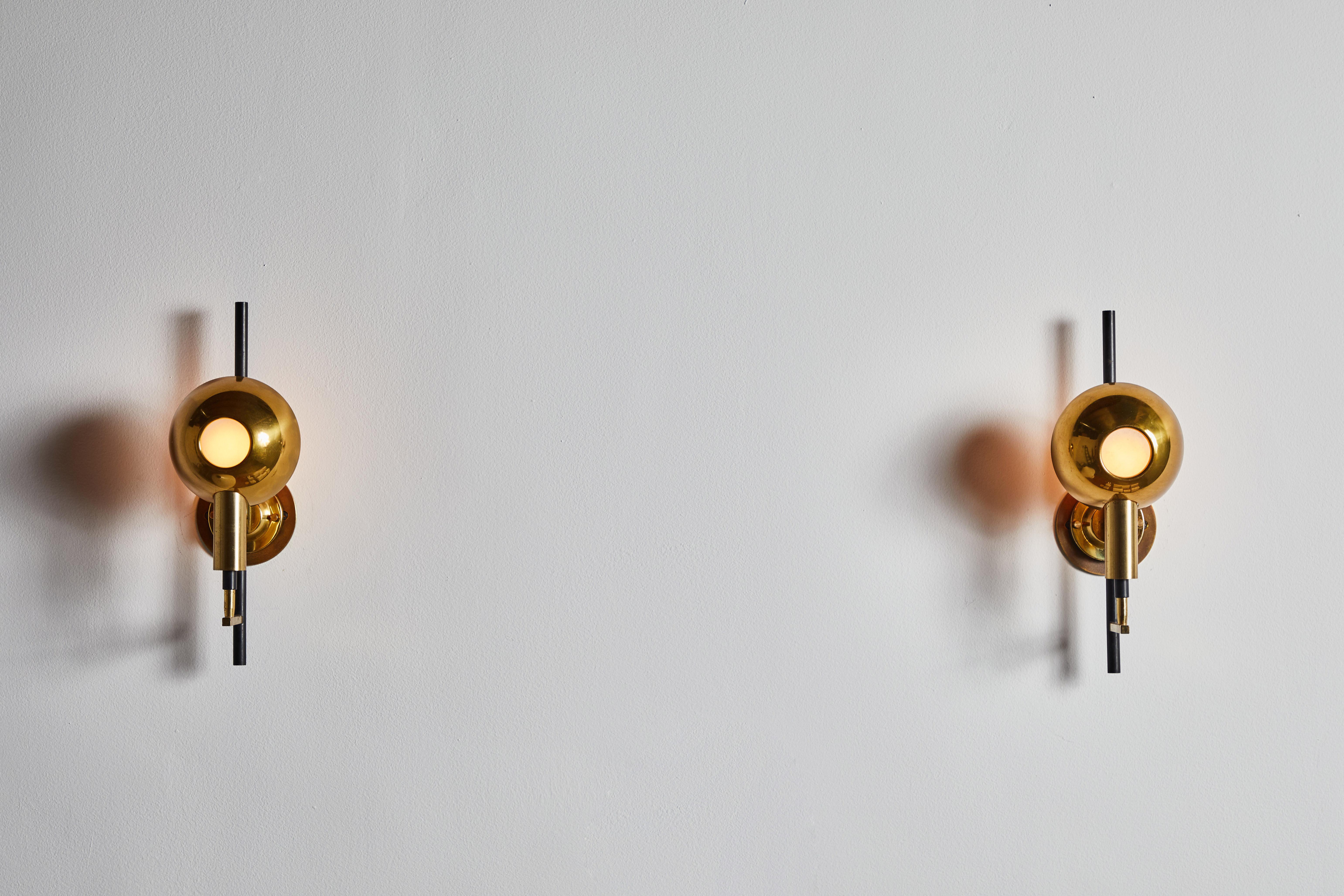 Pair of sconces by Stilnovo. Manufactured in Italy, circa 1960s. Brass, enameled metal. Rewired for U.S. junction boxes. Retains original manufacturers' engraving. Each light takes one E27 100w maximum bulb. Bulbs provided as a onetime courtesy.