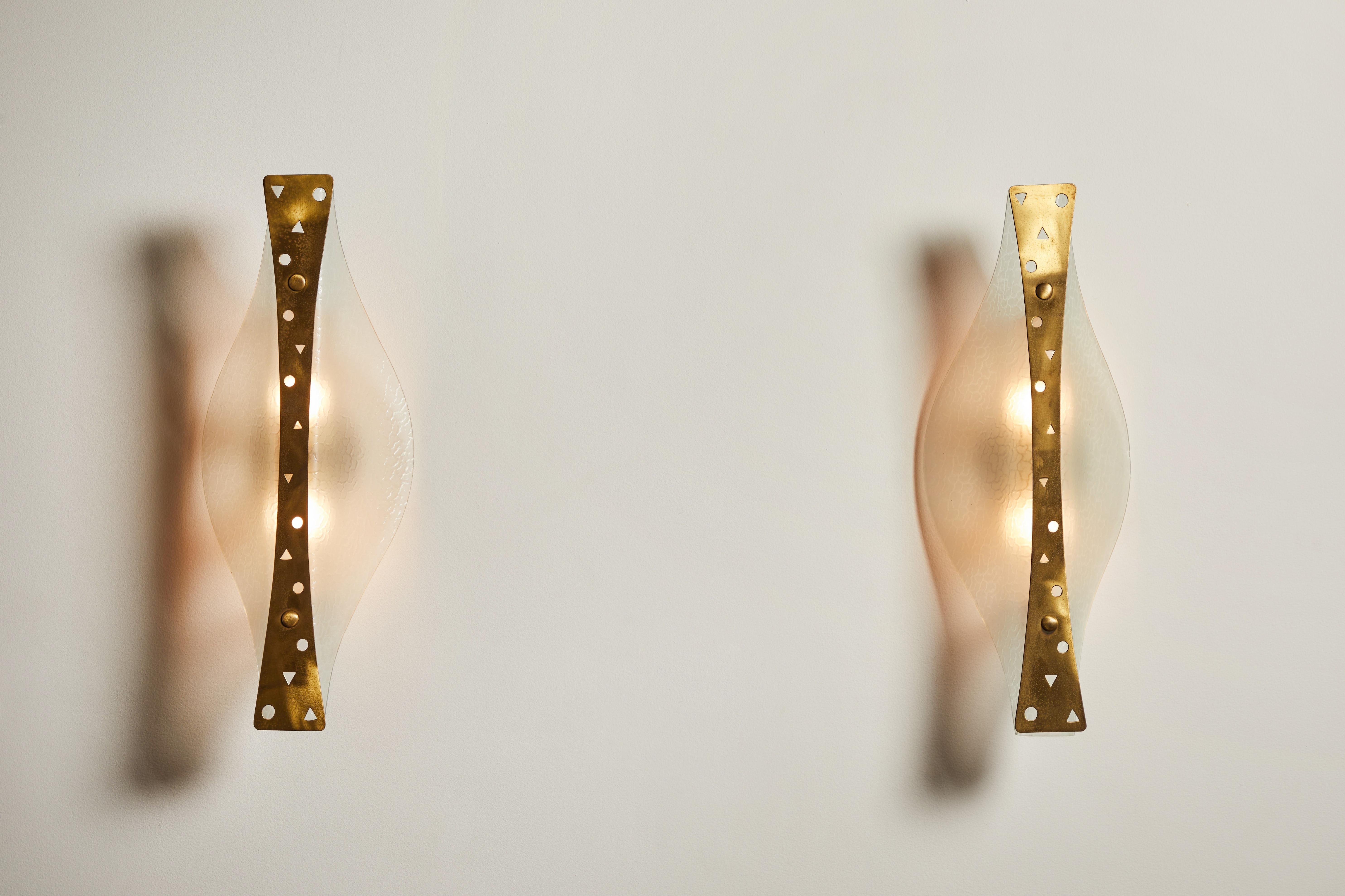 Pair of rare Sconces by Stilnovo. Manufactured in Italy, circa 1950s. Textured glass diffusers, brass armature. Rewired for U.S. junction boxes. Each light takes one E27 100w maximum bulb. Bulbs provided as a one time courtesy.