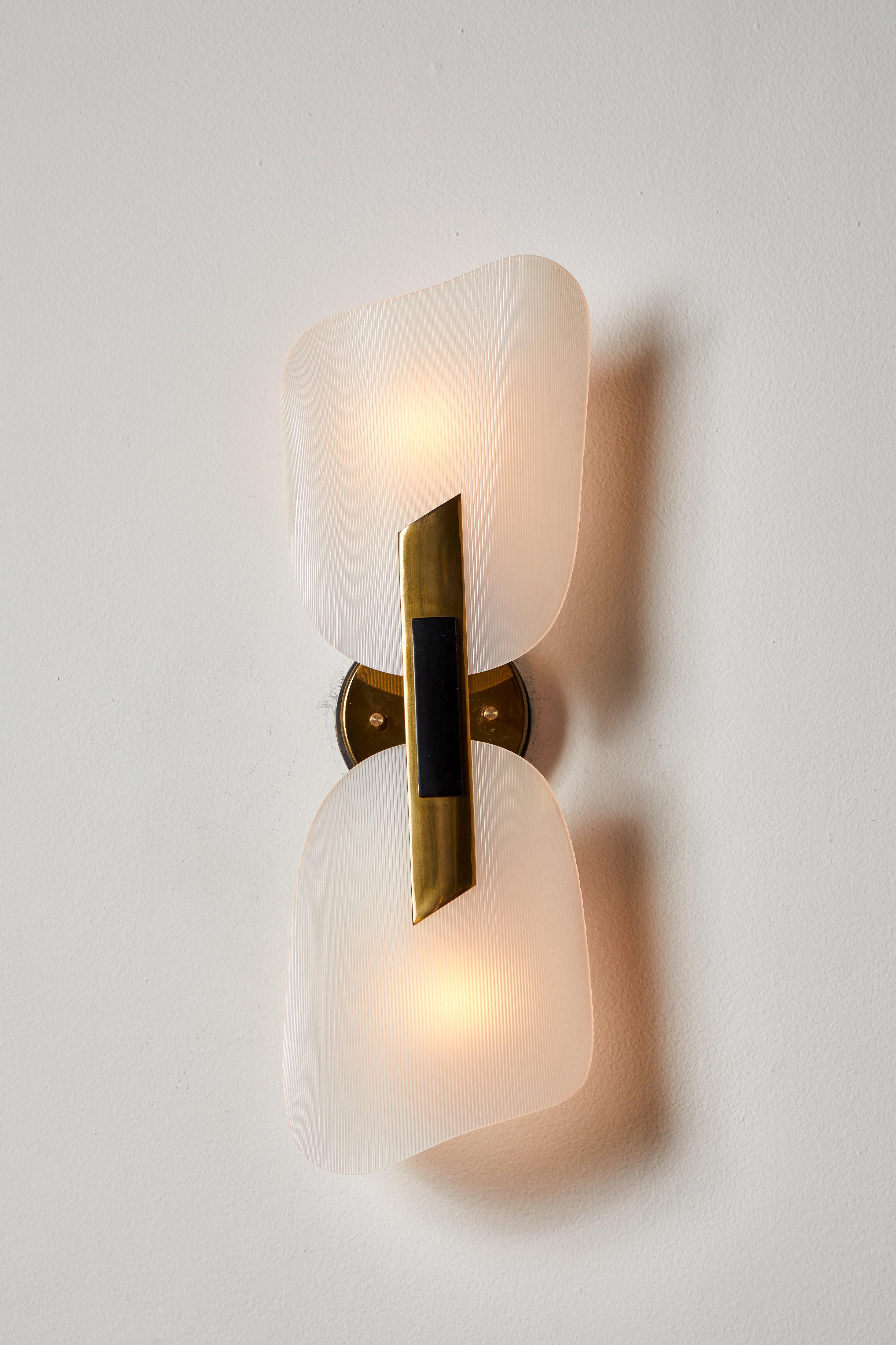 Pair of Sconces by Stilnovo. Manufactured in Italy., circa 1950s Brass, plexiglass. Rewired for U.S. standards. Custom brass backplate. We recommend two E27 60w maximum bulbs per light. Retains original manufacturer's label.