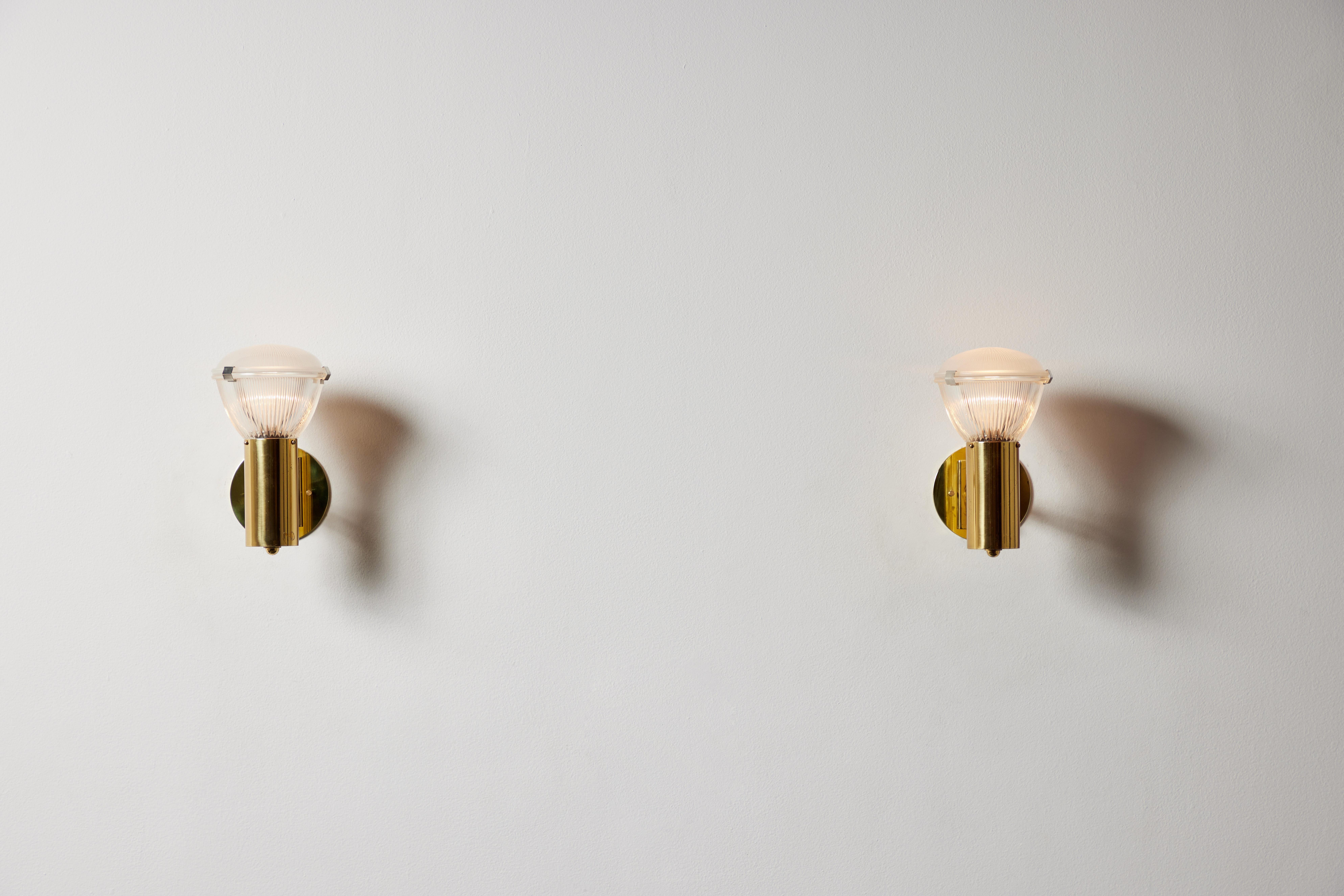 Pair of sconces by Stilnovo. Manufactured in Italy, circa 1960's brass, glass. Custom brass backplates. Rewired for U.S. standards.
We recommend one E27 75w maximum bulb per fixture. Bulbs provided as a one time courtesy.