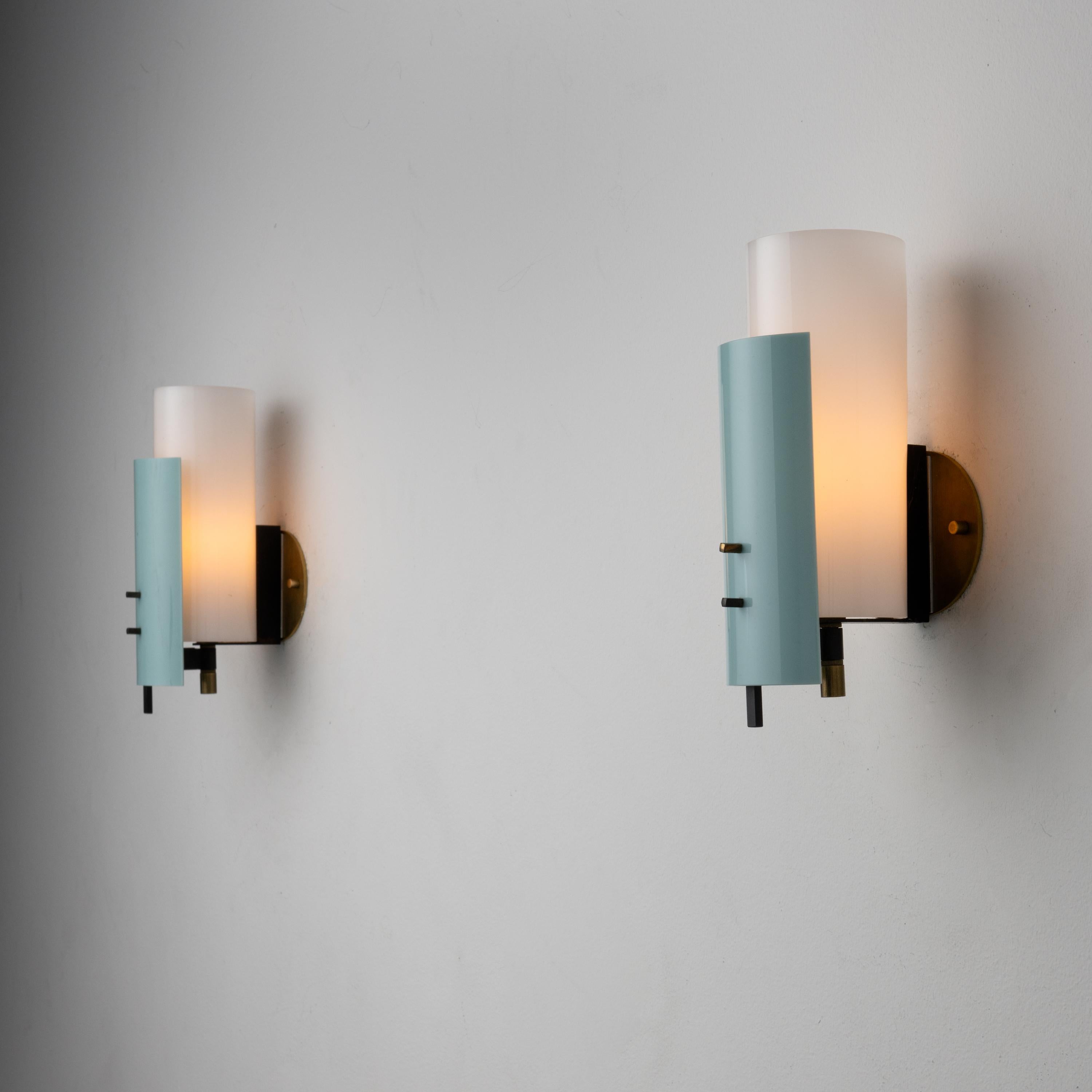 Pair of sconces by Stilnovo. Manufactured in Italy, circa the 1960s. Acrylic and brass. Custom brass backplates. Each sconce takes one E27 25W maximum bulb. Bulbs are provided as a one-time courtesy. Quantity two yellow and two green/grey front