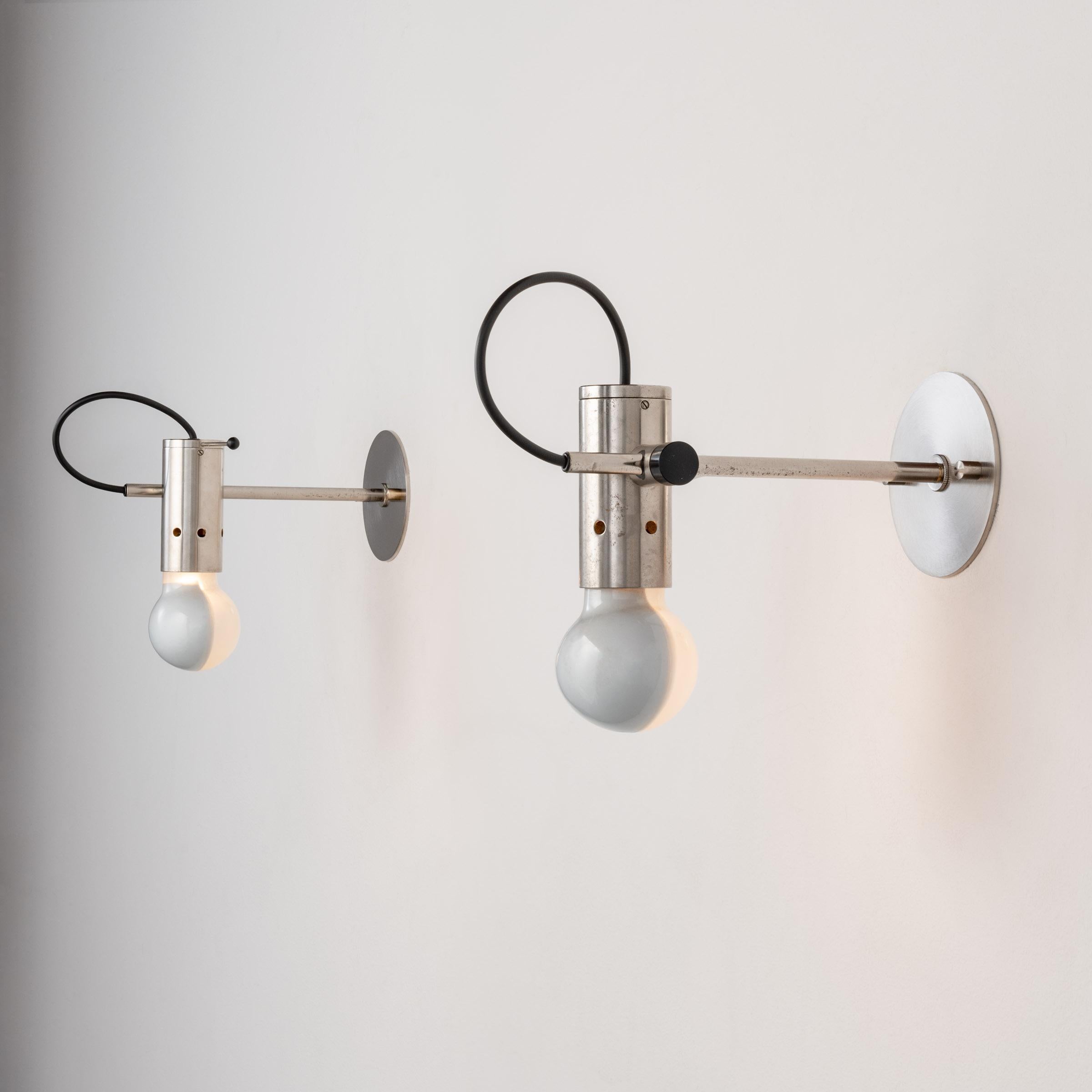 Pair of Sconces by: Tito Agnoli for Oluce. Designed and manufactured in Italy, circa 1960s. Aluminum, chrome, glass. Wired for U.S. standards. Custom chrome backplates. E27 60w bulb included as part of fixture. 

