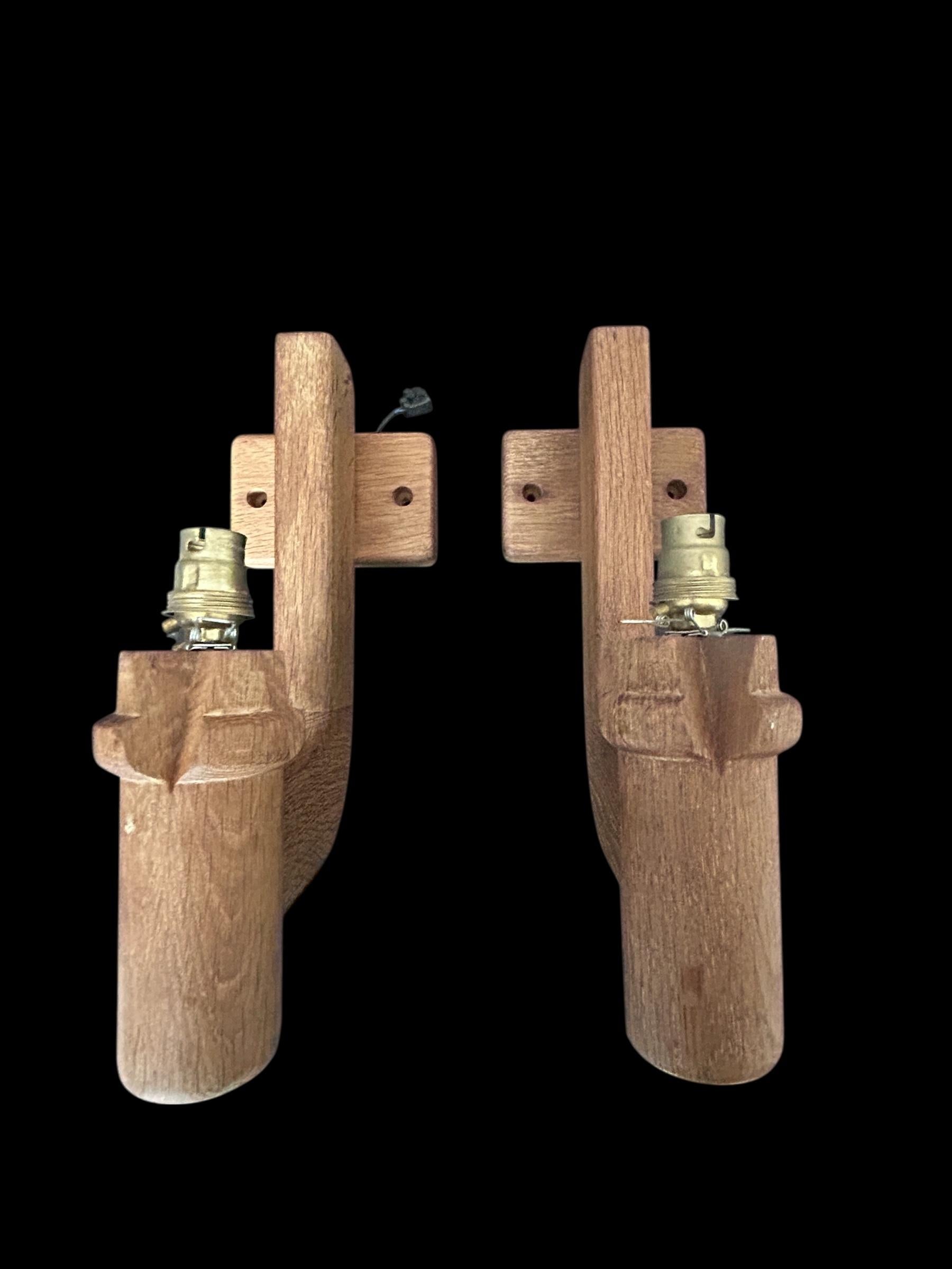 Stunning pair of wooden wall sconces by the iconic French design duo Guillerme & Chambron, renowned for their sculptural craftsmanship and timeless post-war aesthetic.
Crafted in solid oak, these sconces showcase the duo’s signature style: bold