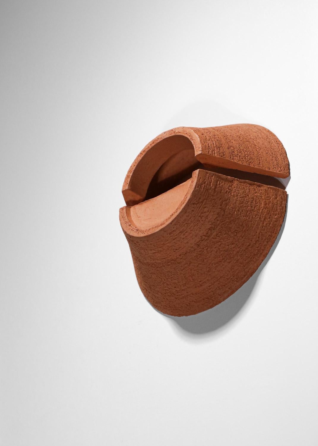 Cette paire d'appliques modernes a été créée et réalisée à la main en grès chamotté selon la technique du tour. Il a ensuite été retravaillé pour retrouver la texture brute de l'argile. La face extérieure est en relief, contrairement aux parties