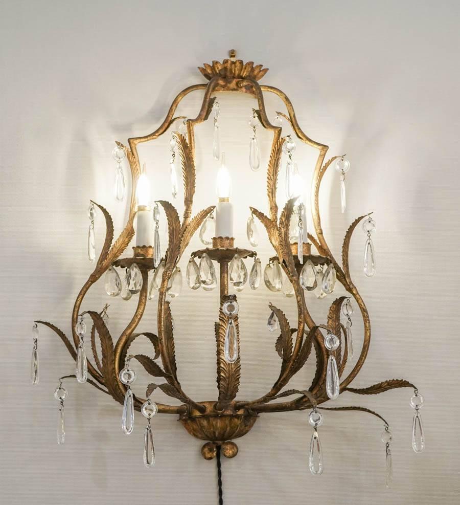 Pair of sconces in gold gilt metal with crystals, 1950-1960. Three lights.