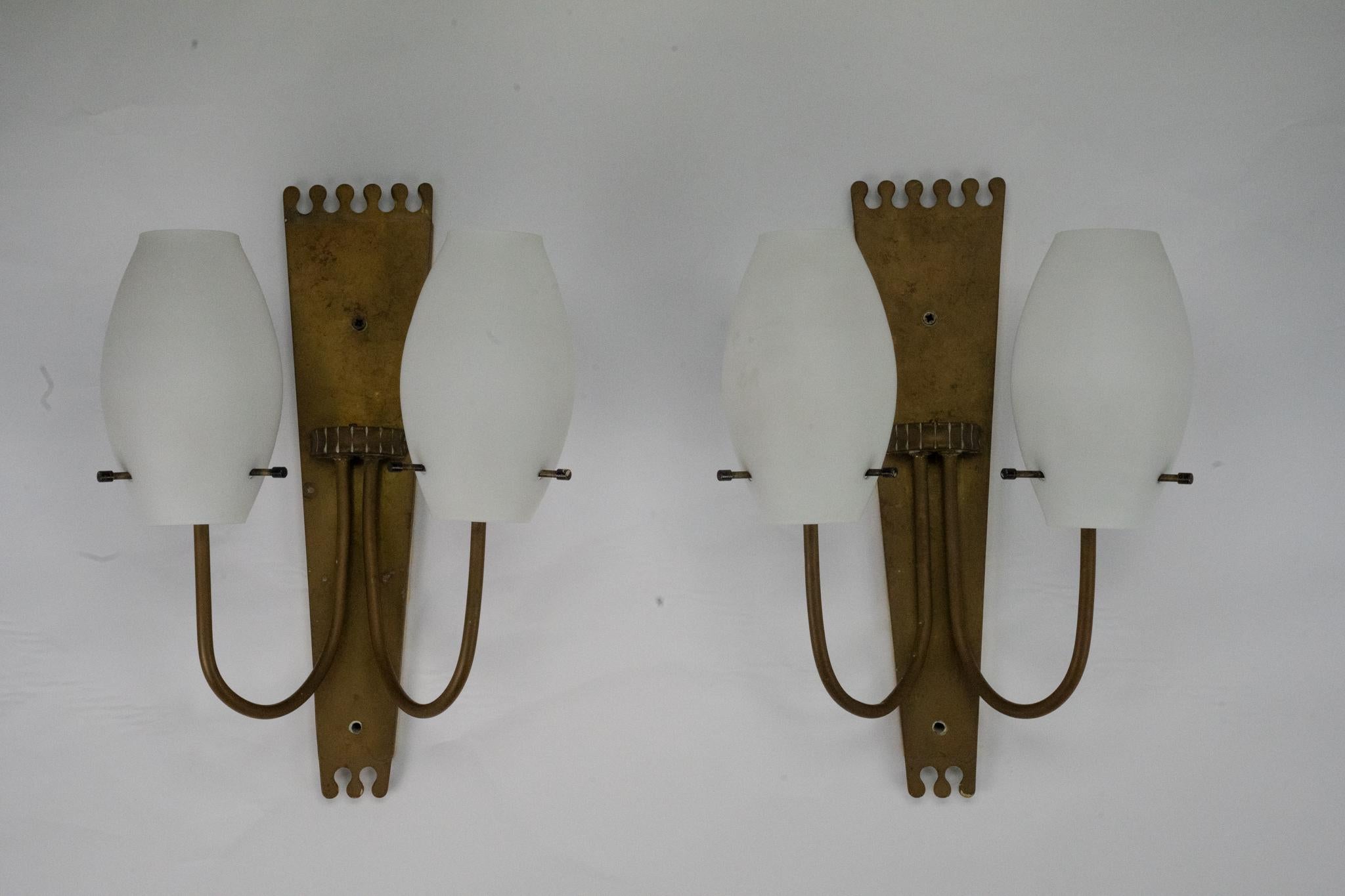 Ensemble d'appliques en laiton et verre opalin rappelant le style moderne italien de Stilnovo et produites en Italie dans les années 50.
Ils sont dans un état vintage original avec des traces d'âge et d'utilisation. Pas de fissures ni d'éclats.