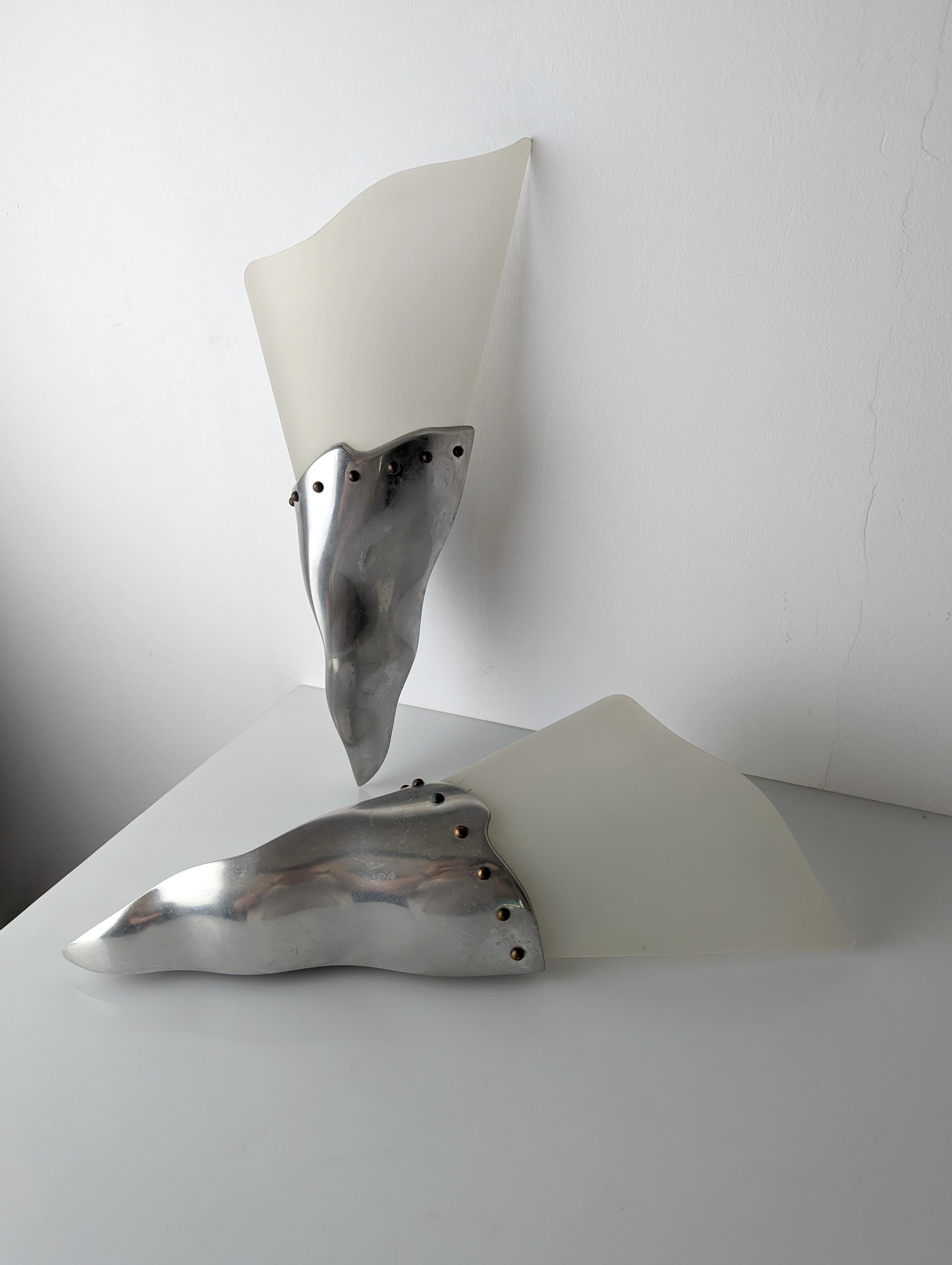 Fantastic pair of wall lights in the shape of a torch or horn from the prestigious French house Lucie Gau Paris in the 1980s. They are made of aluminum with brass details and a molded Plexiglas lampshade.