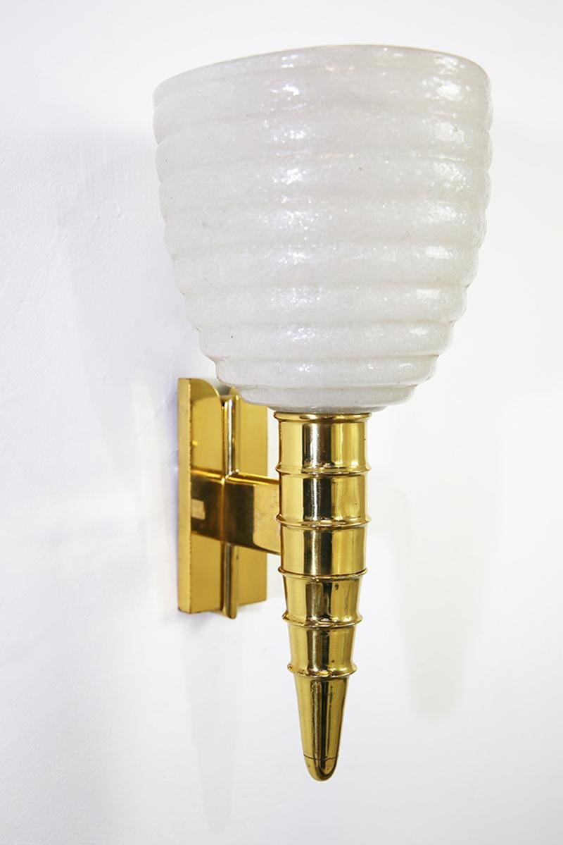 Original wall lamps from the Italian manufacture of Barovier & Toso with transparent hand-blown Murano glass with ribbed motifs and bubbles inside the glass with the Pulegoso technique. The lights are mounted on brass brackets with beautiful vintage