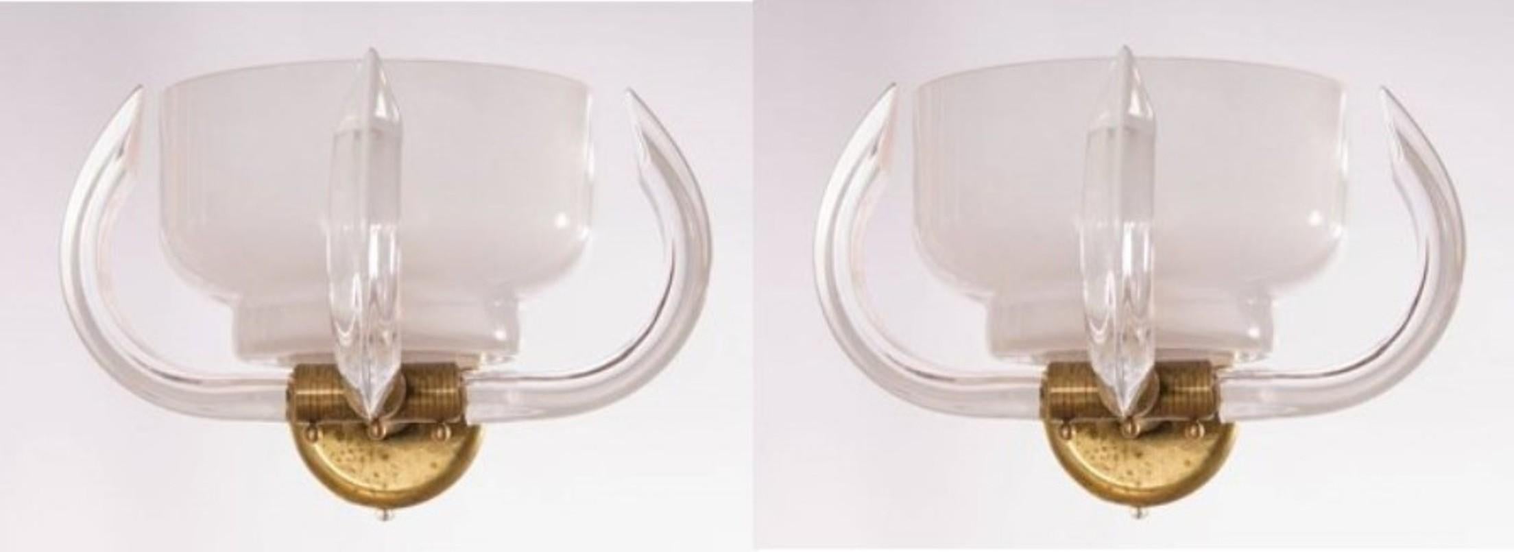 Massive pair of sconces milk color with clear horns in blown Murano glass 1960s Italy
The work of art is constituted of a main huge white bowl in milk color, surrendered by three triedro curved horns, joined together by a massive original brass