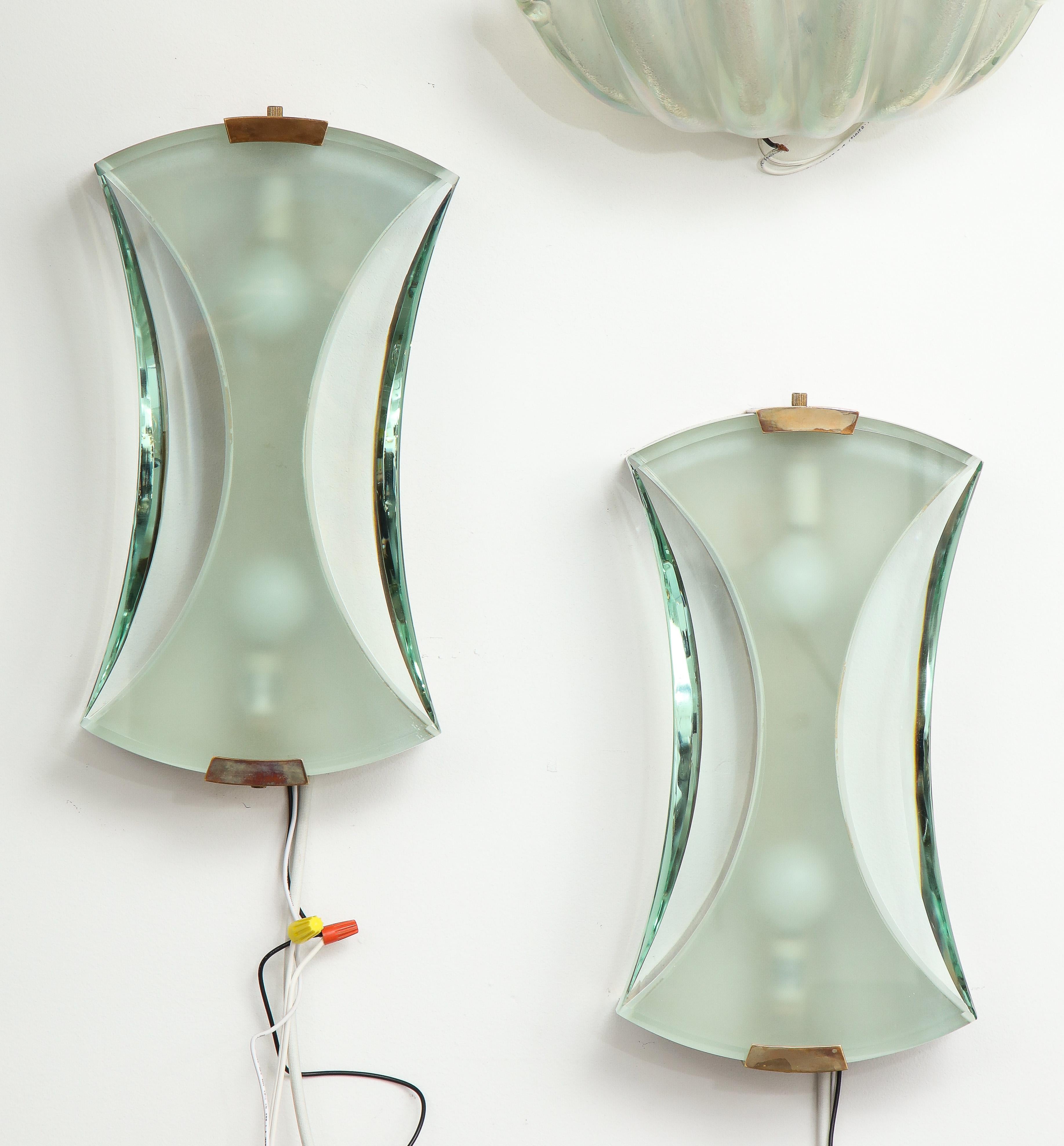 Max Ingrand for Fontana Arte elegant modernist pair of sconces model 2225 in partially frosted and clear polished glass suspended by brass fittings.
Recently rewired to U.S. standards.

Literature:
Franco Deboni, Fontana Arte: Gio Ponti, Pietro