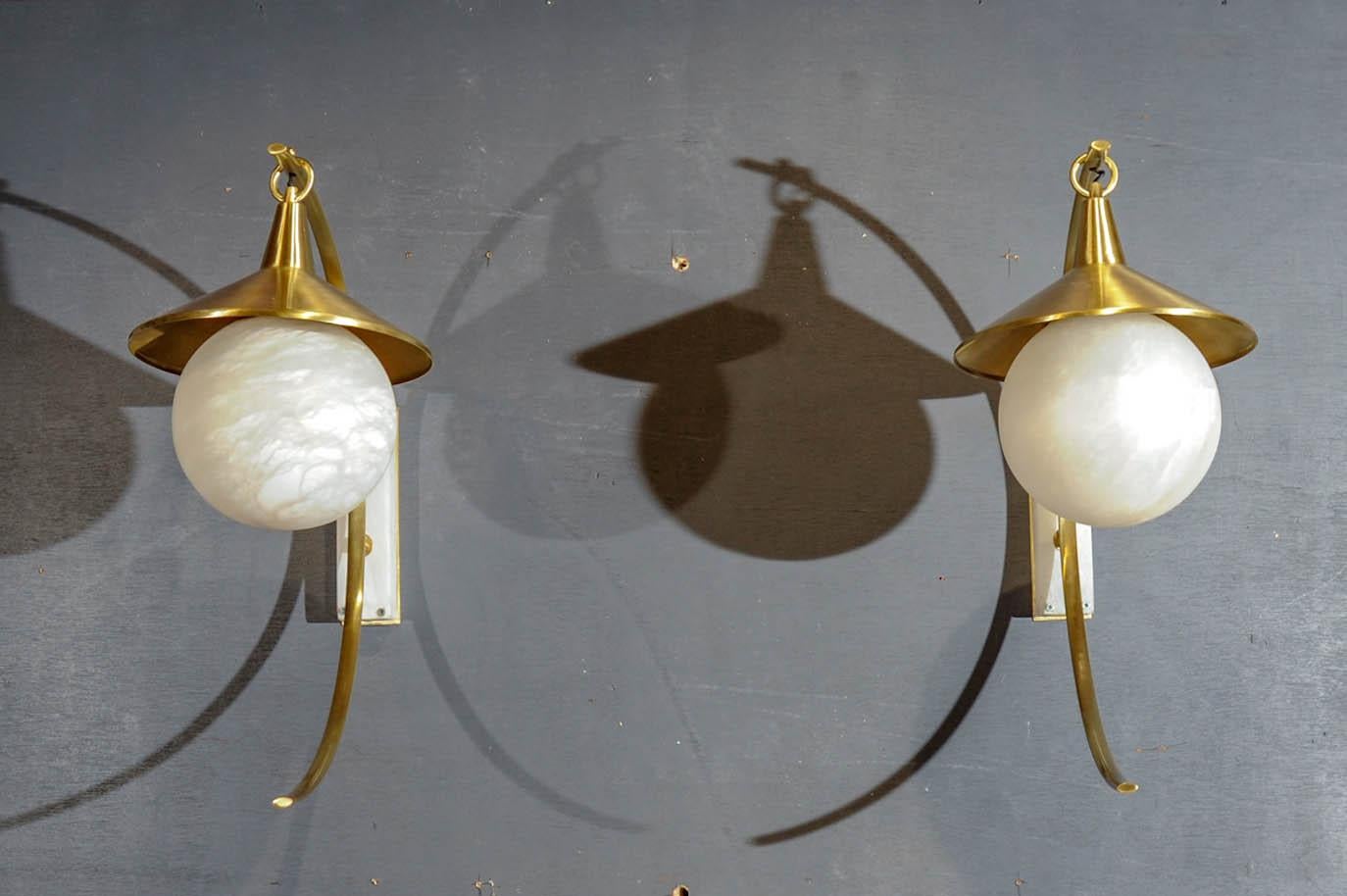 Pair of brass sconces with base and globe in alabaster.
creation by Studio Glustin.