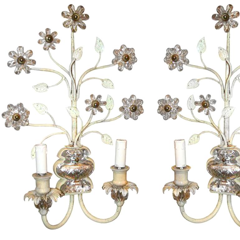 A pair of painted metal two-light sconces with molded glass body and floral details.
 

Measure: Height 21.5 in.
Depth 5 in.
Width/length 14 in.