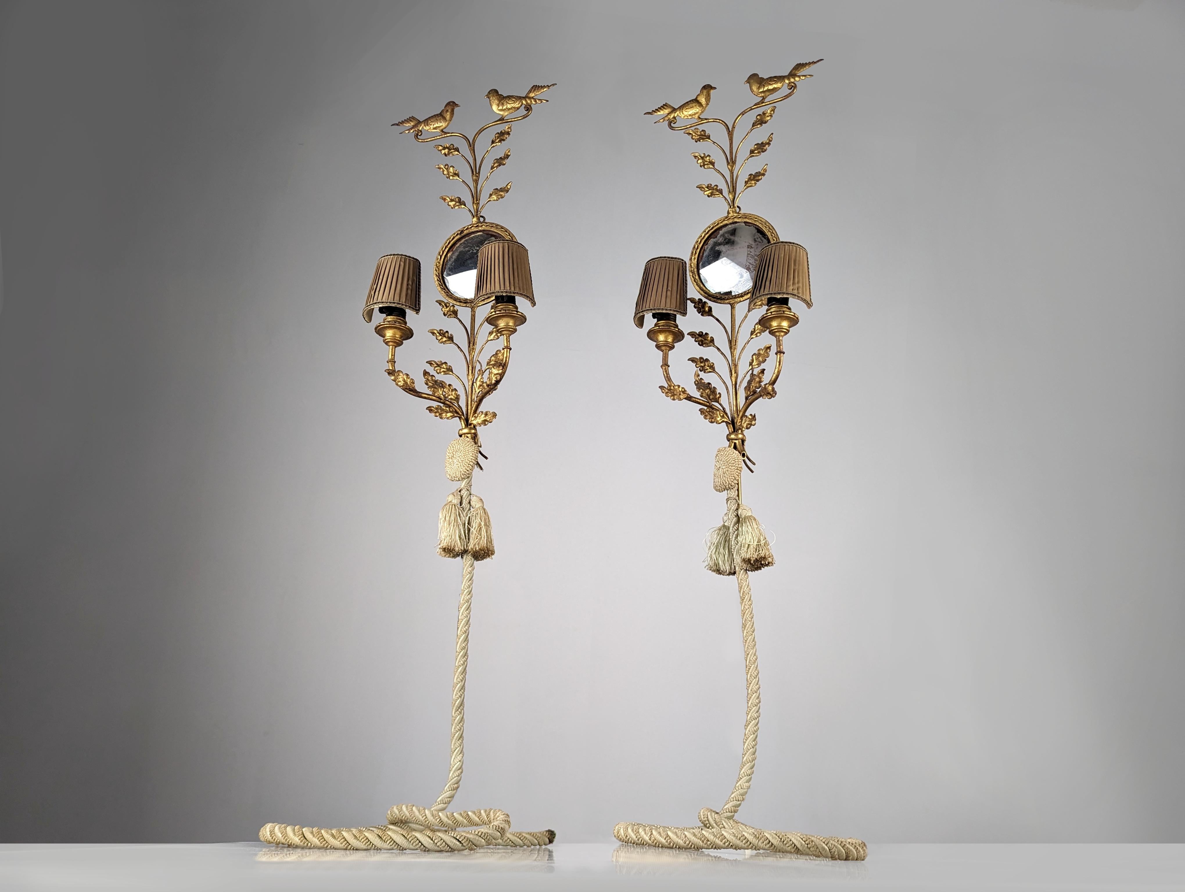 Pair of large gilded iron wall lights with a beautiful shape of branches full of oak leaves on which two beautiful birds perch in their highest part that seem to sing. In the center, a round mirror with a beautiful original patina creates a