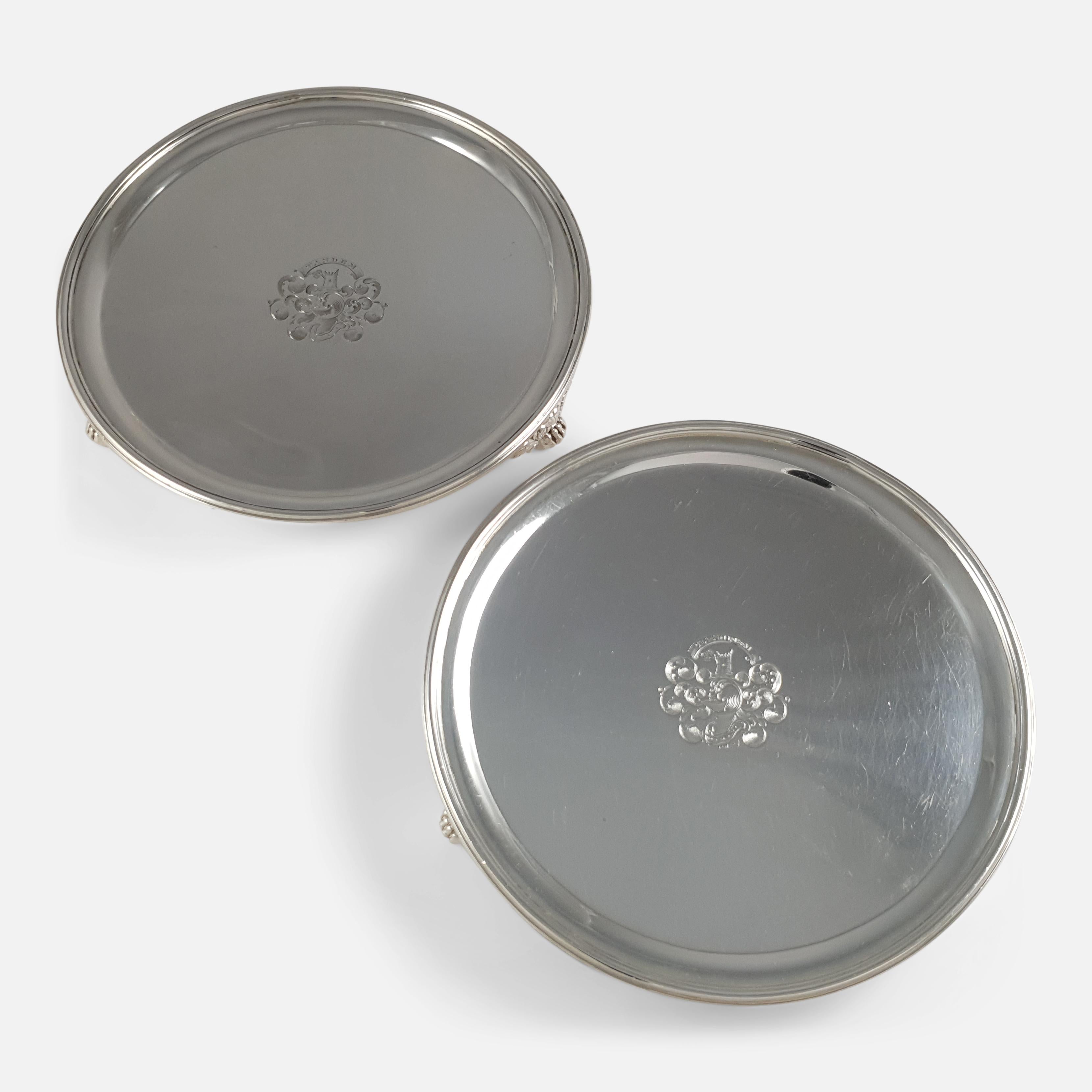 A pair of Scottish George III sterling silver salvers by John McKay, Edinburgh, 1818. The salvers are of plain circular form with a reeded rim, on three paw feet, with the McVicar crested coat-of-arms. The hallmarks are located to the reverse with