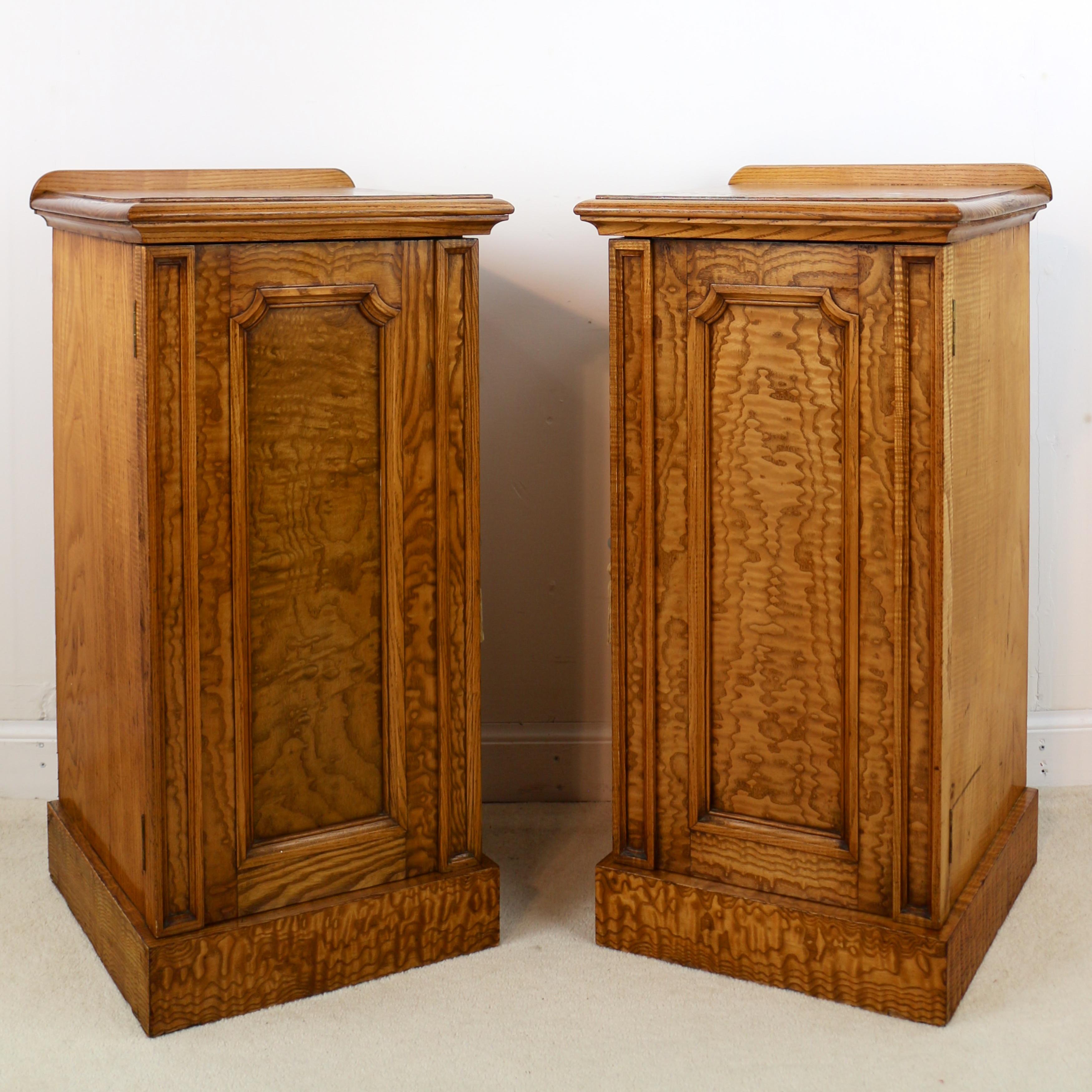 An unusual pair of Scottish William IV burr elm bedside cabinets or cupboards dating to circa 1830. Each with a square top with ledge back and double moulded edge above a front displaying narrow panelled edges flanking a fielded panelled door with