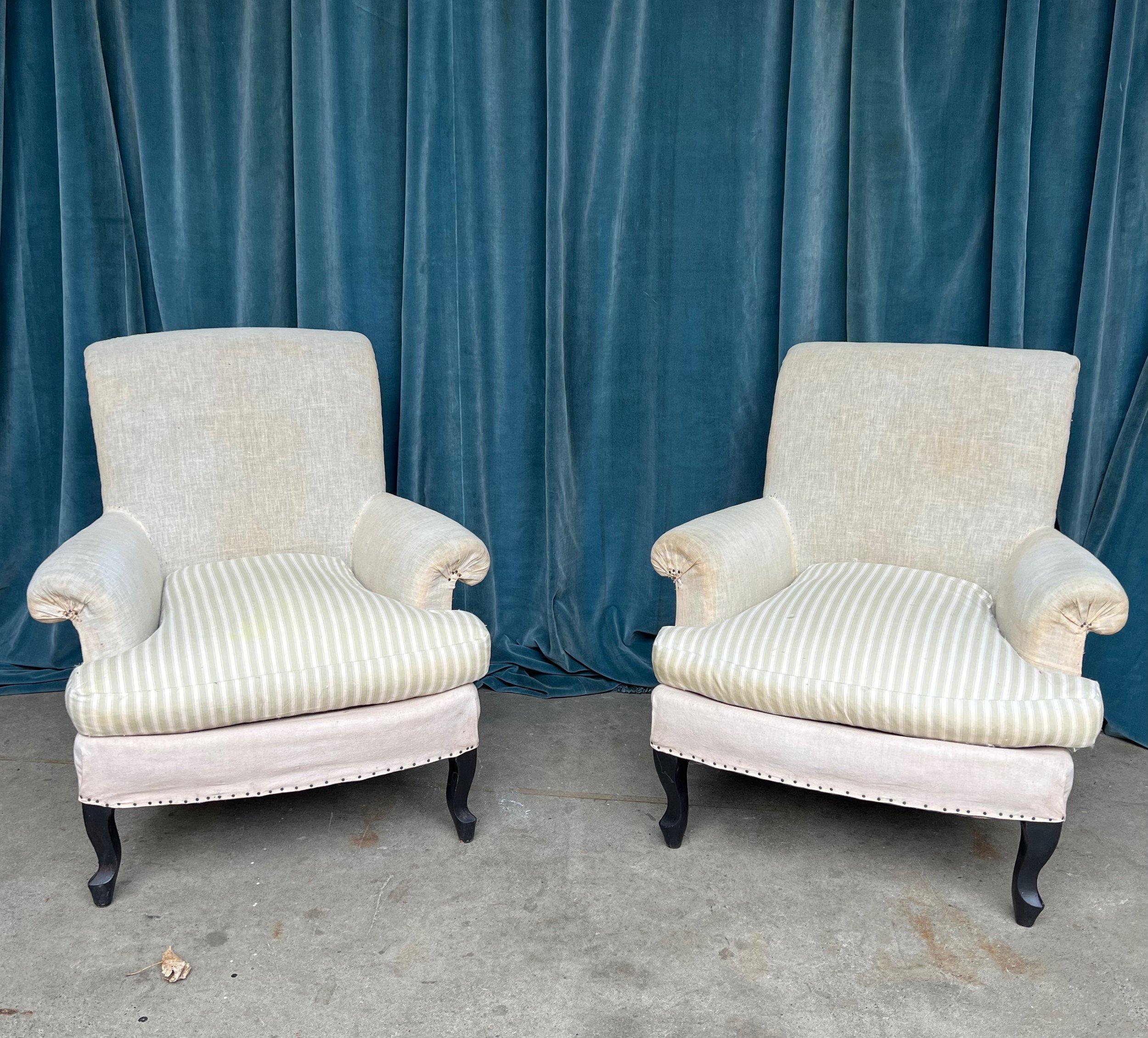 A very comfortable pair of small scale French Napoleon III armchairs from the late 19th century with loose seat cushions. These chairs are a beautiful example of French style with their elegant cabriole legs and scrolled backs. The flowing curves of