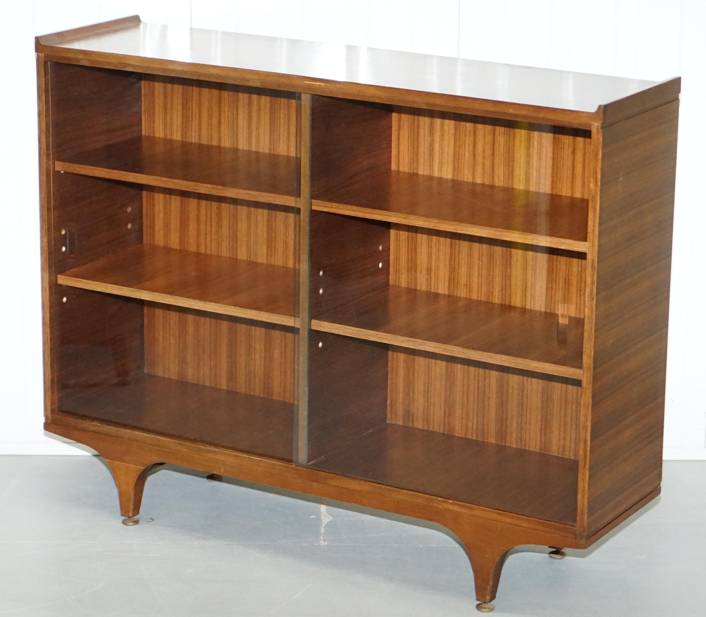 We are delighted to offer for sale this lovely pair of Mid-Century Modern teak bookcases with height adjustable shelves and glass sliding doors

A very good looking and well made paid, the legs are very stylish and sculptural, the shelves are