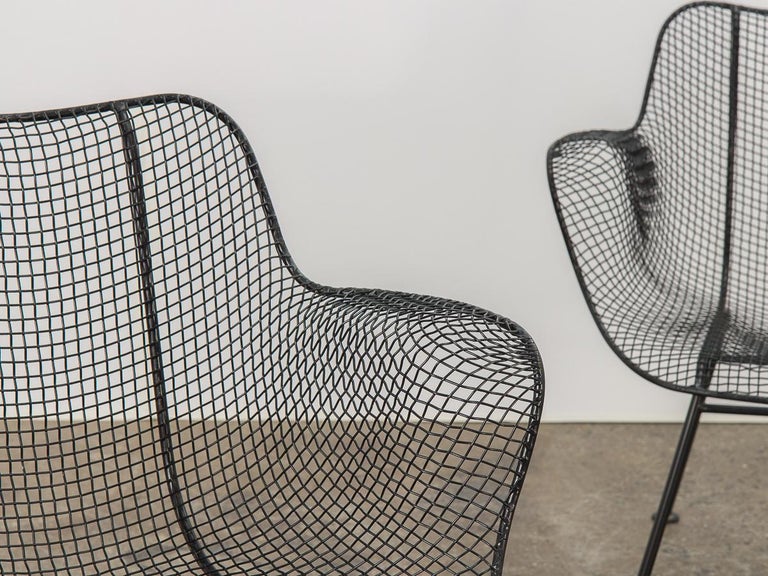 Set of two original sculptura armchairs, designed by Russell Woodard. An airy design achieved by mesh steel on a wrought iron frame. Black satin finish has been recently professionally powder coated. A versatile option for outdoor entertaining, this
