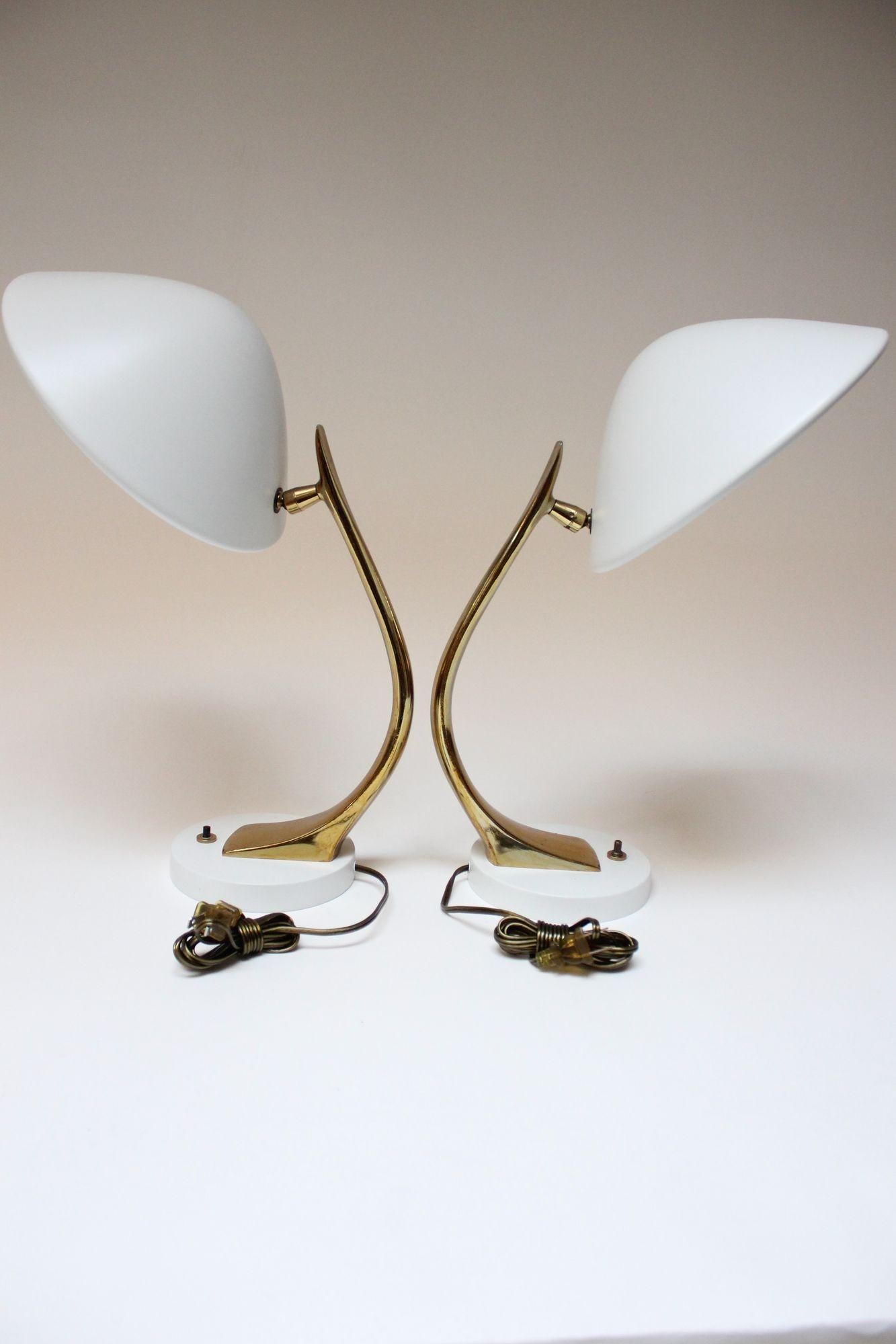 Mid-Century Modern Laurel Lamp Co. enameled-metal and brass-finish table lamps (ca. 1960s, USA). Curved brass-finish metal stem houses domed matte-white metal shade, all supported by circular metal base. Full 360 degree swiveling mobility with tilt