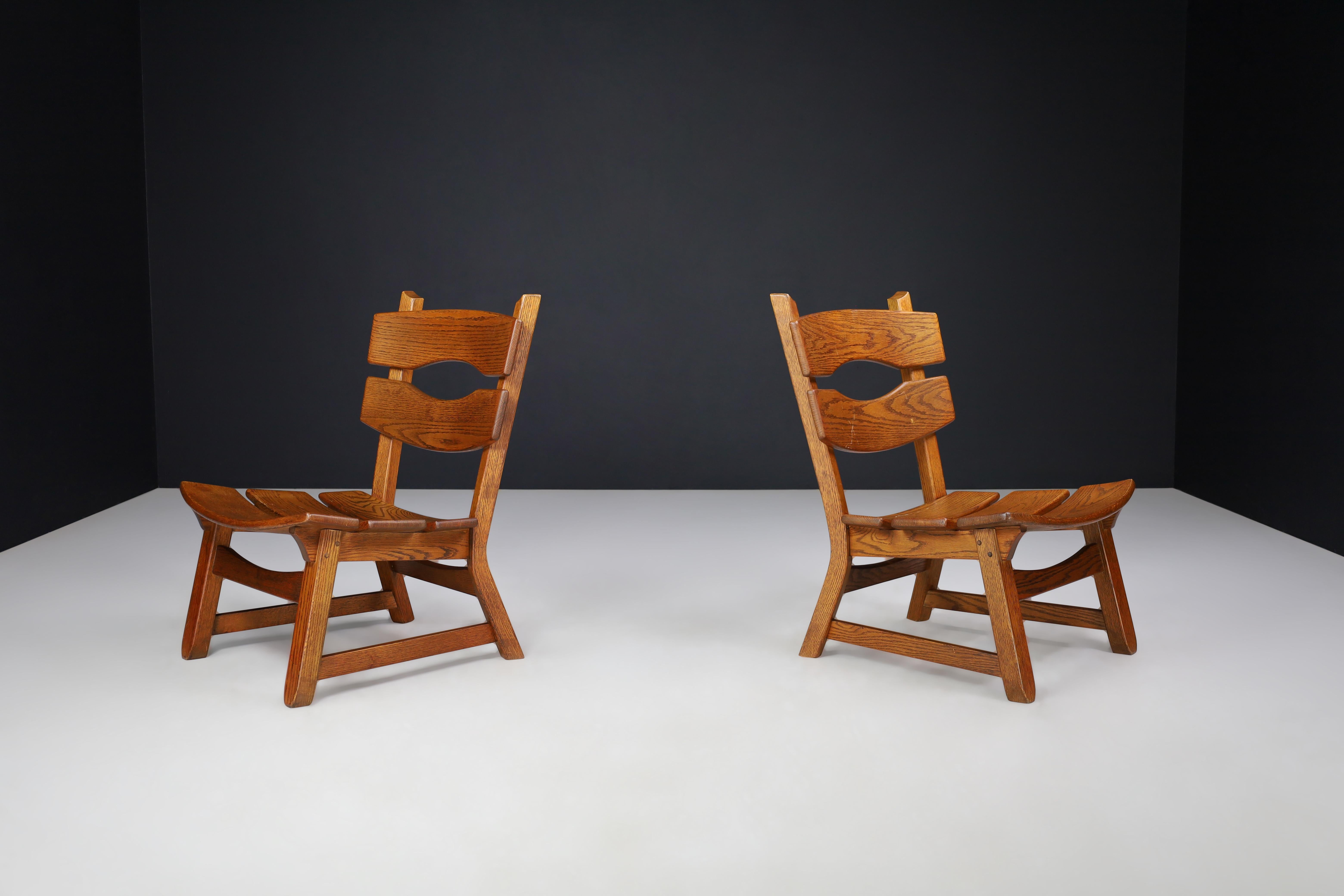 Pair of Sculptural Brutalist Oak Lounge Chairs, France, 1960s

This exceptional pair of lounge chairs embodies the raw elegance and rugged charm of the Brutalist design movement, fused with traditional French Alpine craftsmanship. Made in France