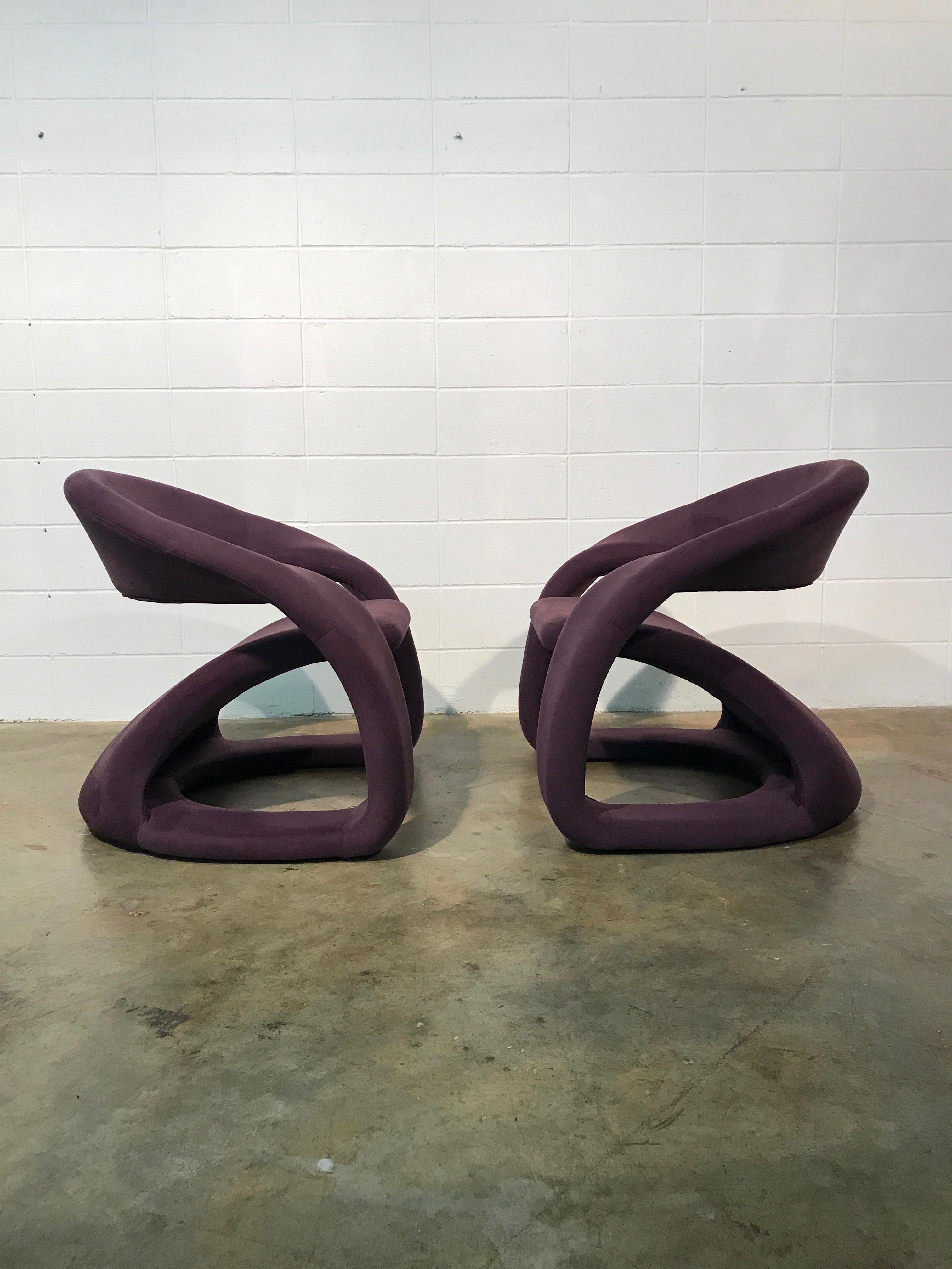Pair of sculptural cantilever chairs with ottoman Memphis style.
Great pair of chairs with ottomans in original purple fabric. Overall in great condition with only a few very minimal knicks in the fabric that isn’t noticeable. Does not detract from