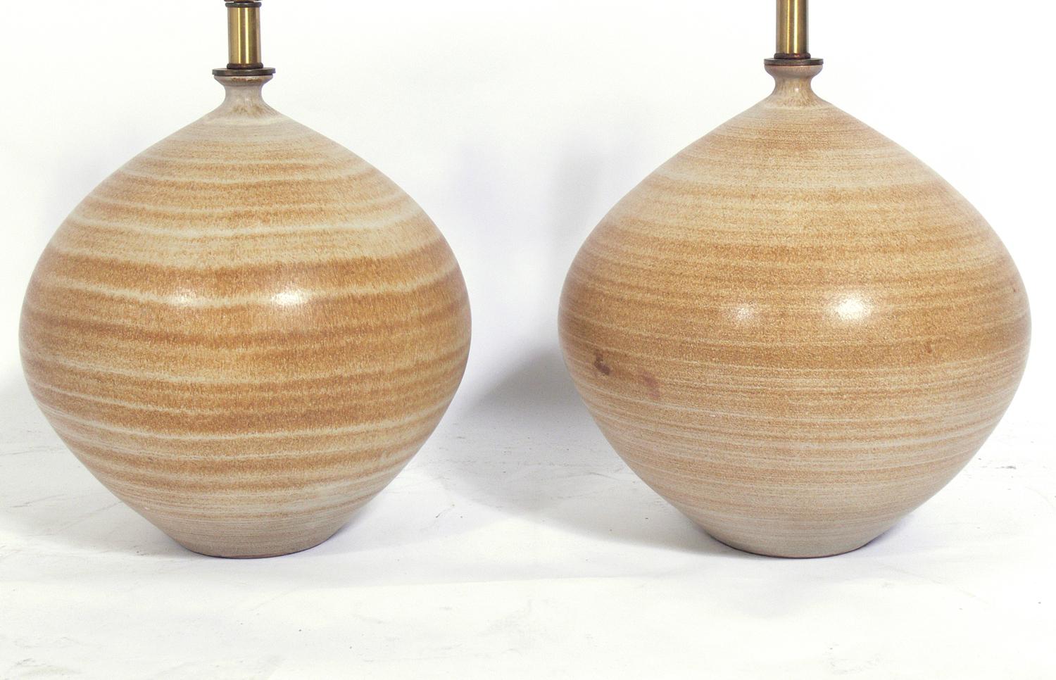 Pair of sculptural ceramic lamps by Design Technics, American, circa 1960s. Signed with DT stamp near cords. Sculptural bulbous form with beautiful striated decoration and nice glaze. The price noted below Includes the shades. Rewired and ready to