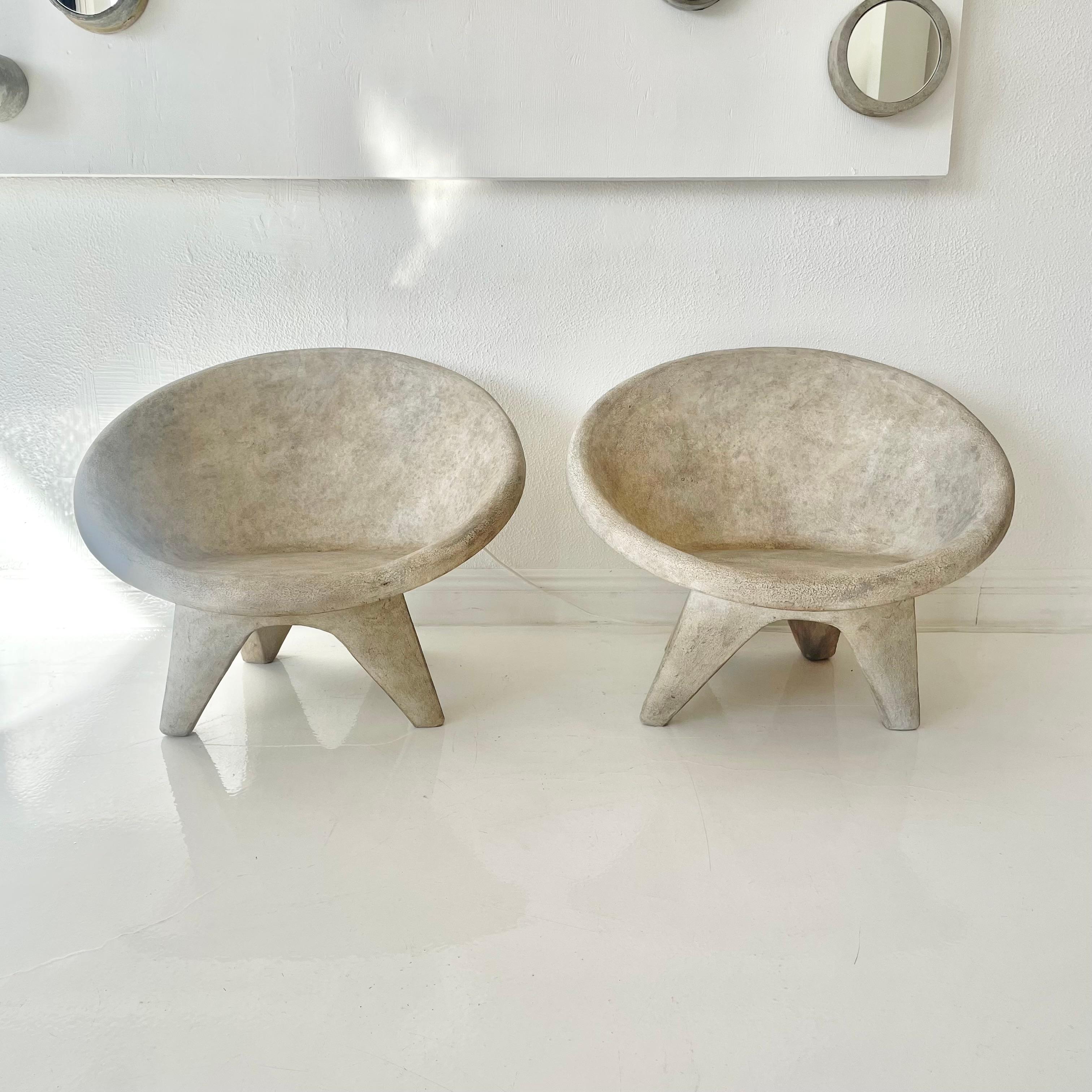 Stunning pair of outdoor chairs made of solid concrete and each with a perfect and unique patina. Round saucer seat with angular legs. Incredible modern design perfect for any outdoor space. Factory drilled hole in the seat of each chair for water