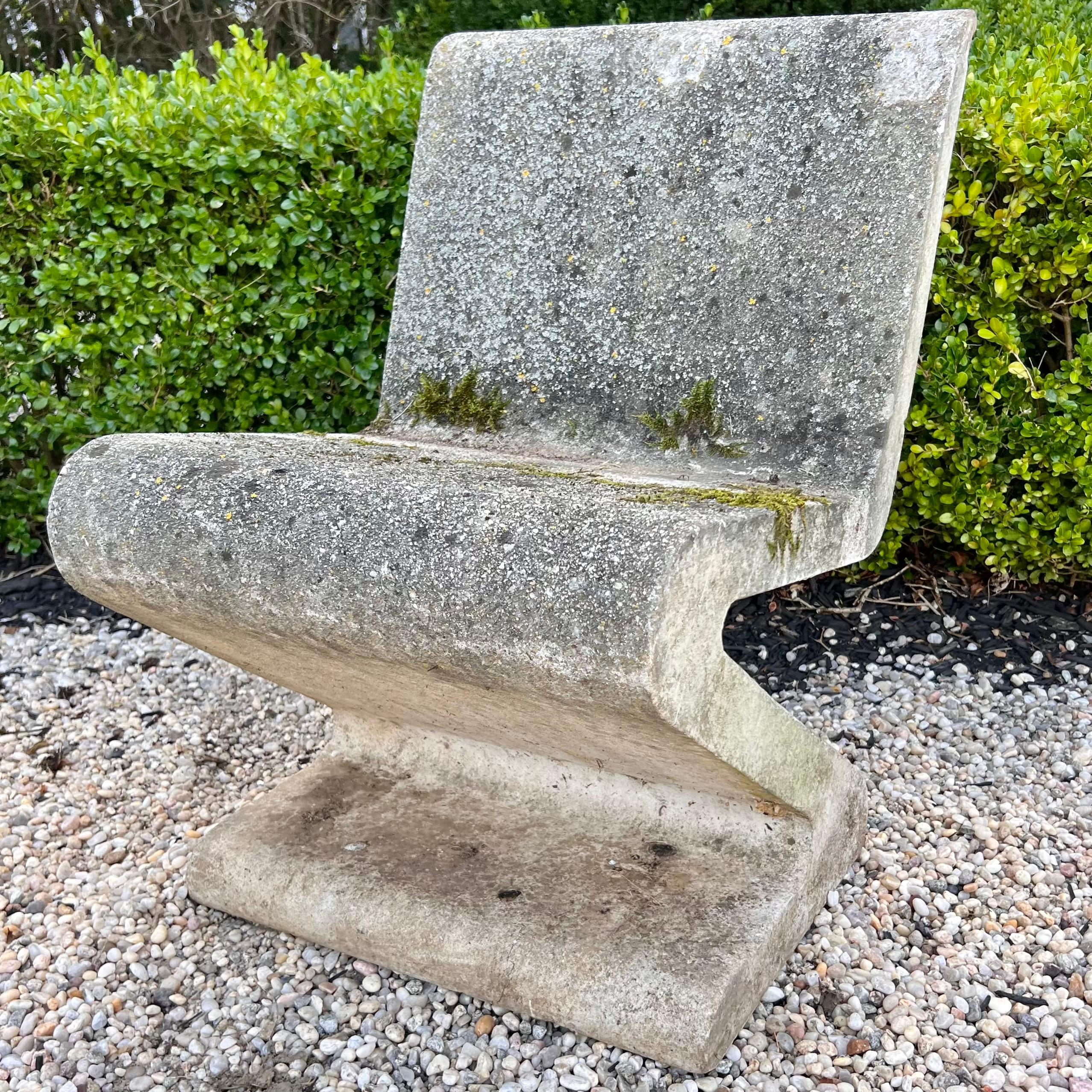 Substantial set of concrete zig zag chairs. Exceptional presence. Stunning presence and design. Industrial steel rebar runs inside the concrete reinforcing the chair and table giving them extra strength. Reminiscent of the Rietveld Zig Zag chairs,