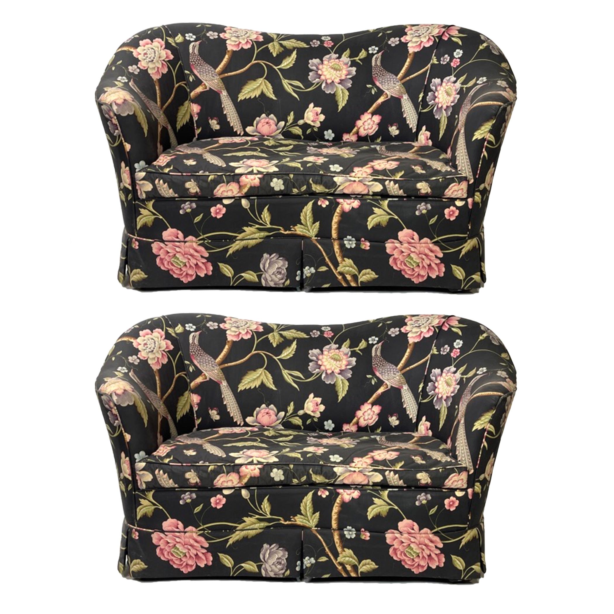 Gorgeous pair of sculptural settees with a lovely and whimsical chintz upholstery. There is an unfortunate tear on the right side of one of the settee side panels, that could possibly be repaired with the extra upholstery fabric that we will include.